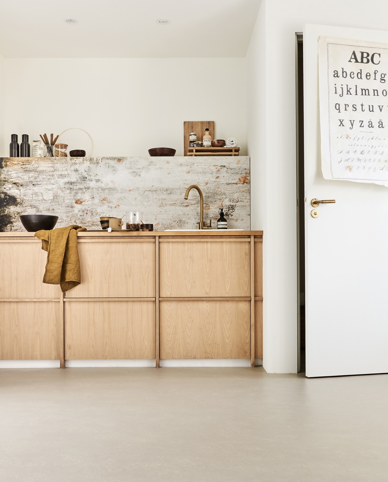 Marmoleum vloer kleur Kwarts vtwonen 16, per m² € 48,-M.m.v. behangfabriek.com (vuil- en water­afstotend behang Concrete van Kitchenwalls achter keuken), vtwonen.nl (peper- en zoutstel van Stelton, snijplank van Butler, bruineschaaltjes op plank rechtsboven van HKliving), basiclabel.nl (ronde houten schalen), archive-store.nl (wafeldoek), hkliving.nl (keramieken schalen, mok met oor), skins.nl (handzeep van Aesop). Overig privébezit. vtwonen 01-2022 | productie Tanja Saarberg | styling Marlies Does | fotografie Bart Brussee | assistentie Judie Jonker