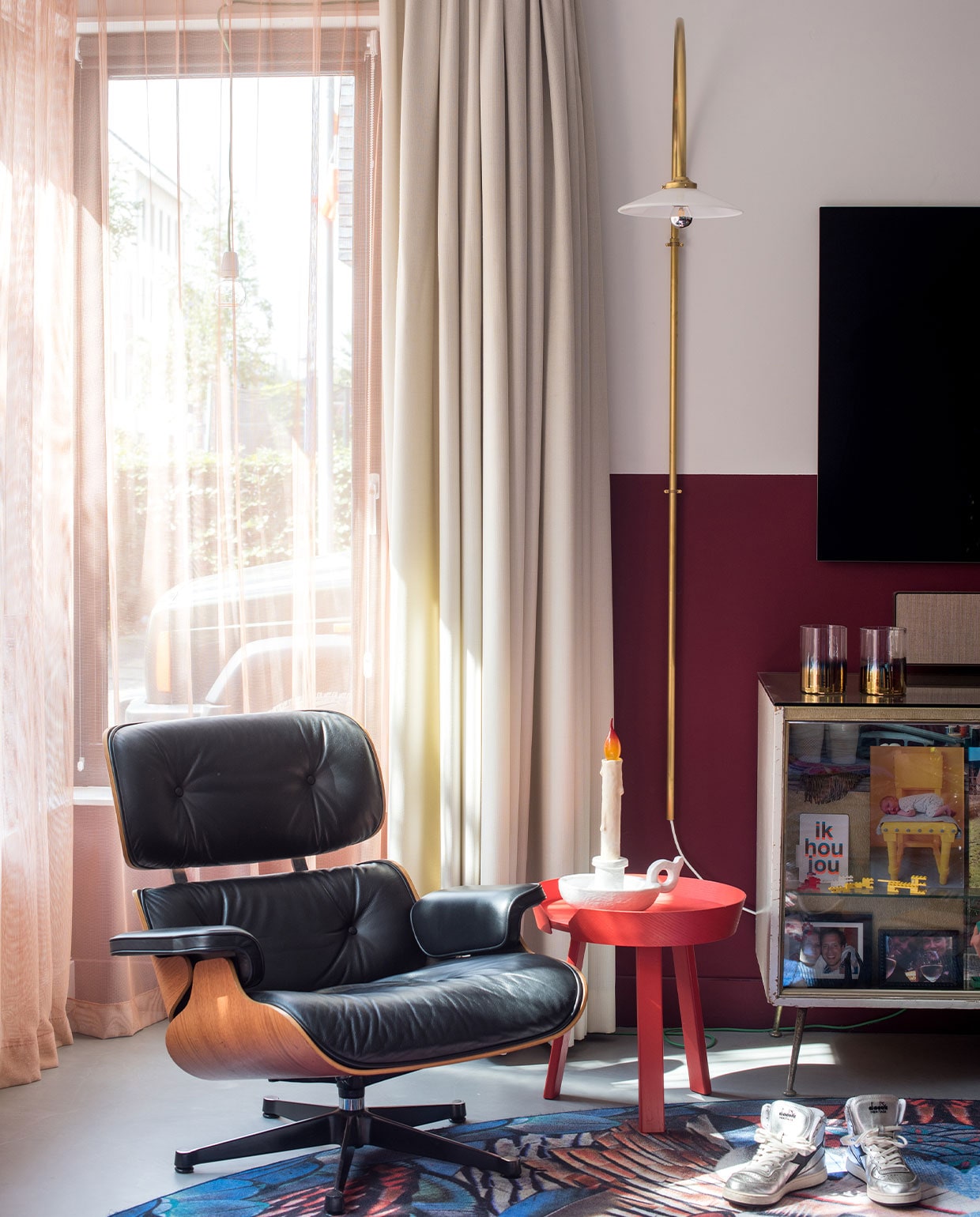 Muurverf onderkant wand Markant van Histor. Stoel Eames Lounge Chair Vitra, vloerkleed Moooi Carpets, bijzettafel Muuto, lamp Muller van Severen, ledlamp Bugia, tafelkaars Seletti, oude toonbank uit juwelierswinkel, in toonbak onder andere privéfoto’s, kaarsenhouders Pols Potten. Schoenen Diadora Heritage. Overgordijnen gemaakt door stoffeerder, vitrage van Kvadrat-stof. vtwonen 2-2022 | styling Kim de Groot | fotografie Anke Leunissen | tekst Mirjam Rosema-Verhulst