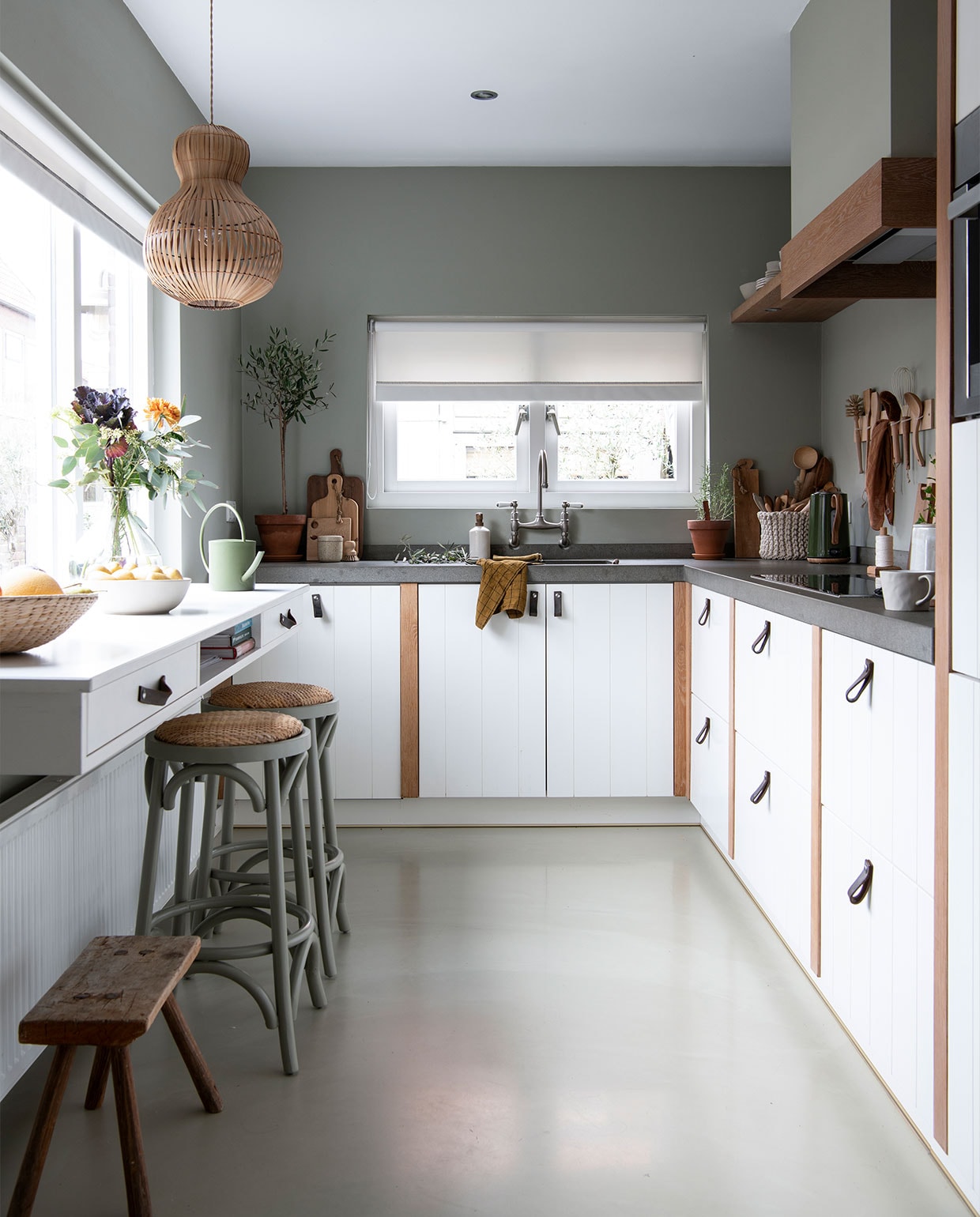 Keuken op maat gemaakt door een bedrijf dat niet meer bestaat. Kraan herkomst onbekend. Bar ontworpen door Stephanie, uitgevoerd door een timmerman. Groen geverfde barstoelen Loods 5. Krukje rommelmarkt. Muurverf Mild Tundra van Flexa Pure. Lepelrek DIY-idee van Janneke Peeters, dat Stephanie aanpaste. Geruite theedoek Villa Augustus. Bak H&amp;M Home. Broodplanken kringloopwinkel. Gieter Sissy-Boy Homeland. vtwonen special DIY 3-2021 | productie Inside Homepage | styling Janneke Peters | fotografie Louis Lemaire