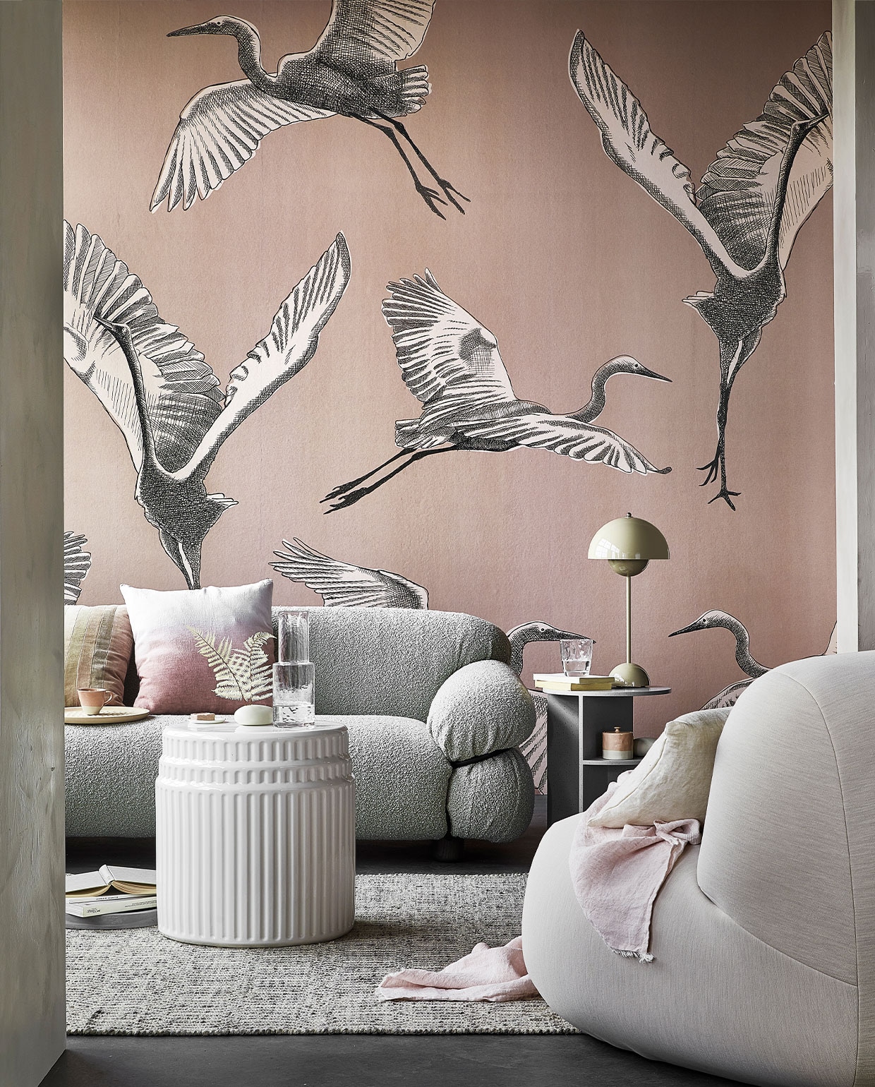 Digitaal behang Graphic Nature, 6 banen van 280x50 cm, totaal (lxb) 280x300 cm € 149,-. M.m.v. kasstoor.nl (bank, kussen met roze kleurverloop, salontafel van wit keramiek, bijzettafel van grijs keramiek, fauteuil), homestede.nl (grijze stenen schaal, houten dienblad, tafellamp), paviljoennoord.com (gestreept kussen, mini-bordje, amberblok), zara.com (kop, karaf, glas, roze pot met deksel), loods5.nl/design (vloerkleed), letoile.store (wit porseleinen vaasje, linnen kussen), bymolle.com (plaid), pure-original.nl (muurverf Fresco in kleur Ashes). Overig privébezit. vtwonen 05-2021 | productie Tanja Saarberg | styling Danielle Verheul | fotografie Peggy Janssen | assistentie Niels Kist, Danique van Rijn