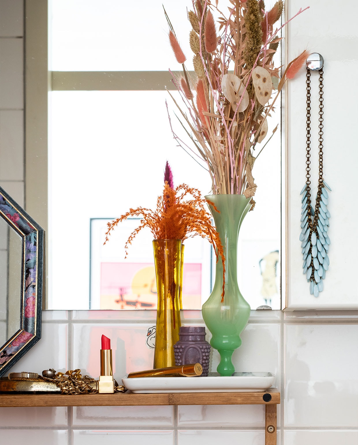 Spiegel en gele vaas kringloopwinkel. Groene vaas Fleurmonde. Paarse pot Noordermarkt. Ketting souvenir uit Marokko. vtwonen 02-2022 | productie Insidehomepage | styling Kim Timmerman | fotografie Louis Lemaire