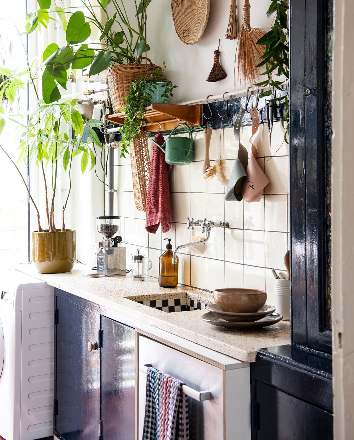 Theedoek Pluk Den Haag, borden en schaal tweedehands. Zeepdispenser Little Green Shop. Koffiemolen Nemox, bloempot DM Deco. Brabantia-gieter tweedehands, slabbetjes Achtung Baby, kwasten en borstels Dille &amp; Kamille. Planten Pachira, Monstera, Peperomia, Hoya. Overig herkomst onbekend. vtwonen 02-2022 | productie Insidehomepage | styling Inge van Lieshout | fotografie Louis Lemaire