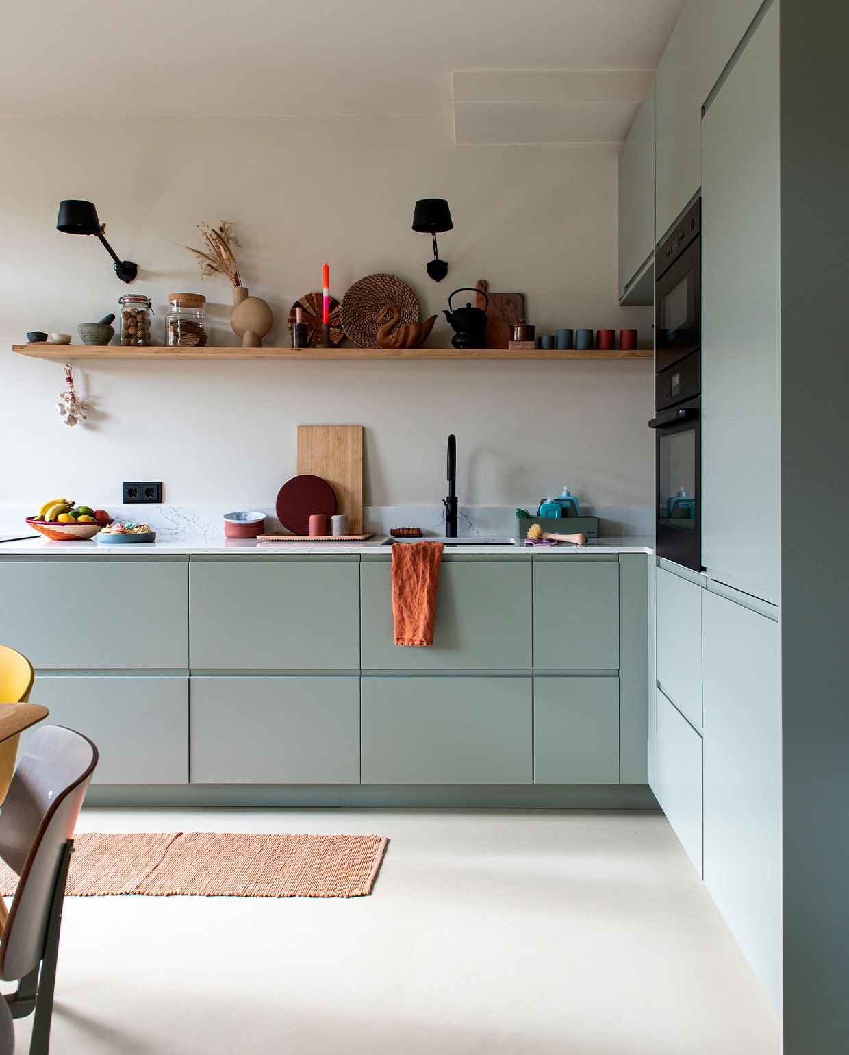 Keuken met binnenkasten van Ikea en fronten via Frontz, aanrechtblad composiet Carrara Unistone via The Stone Art House, kraan Quooker, apparatuur Ikea. Muurverf Spider Mum 310 van Vestingh Paint. Lampen Tonone. Wandplank Bremer’s Houthandel Haarlem. Kleed Tica. Gietvloer Fusion van Senso. Broodplank en pot met kurk Ikea. Ronde snijplank Hay via Drifter Store. Schalen Archive Studio en Hay. Koffiekopjes Archive Studio. Marmeren plank Yaya. Theepot Bredemeijer. Vaas Sphere Bulb medio van 101 Copenhagen. Manden vintage en uit Afrika. Theedoek Tales via Petit Depot. vtwonen special kidsbijlage 13-2021 | productie De Binnenkijkers | styling Jeske Weel | fotografie Caroline Coehorst