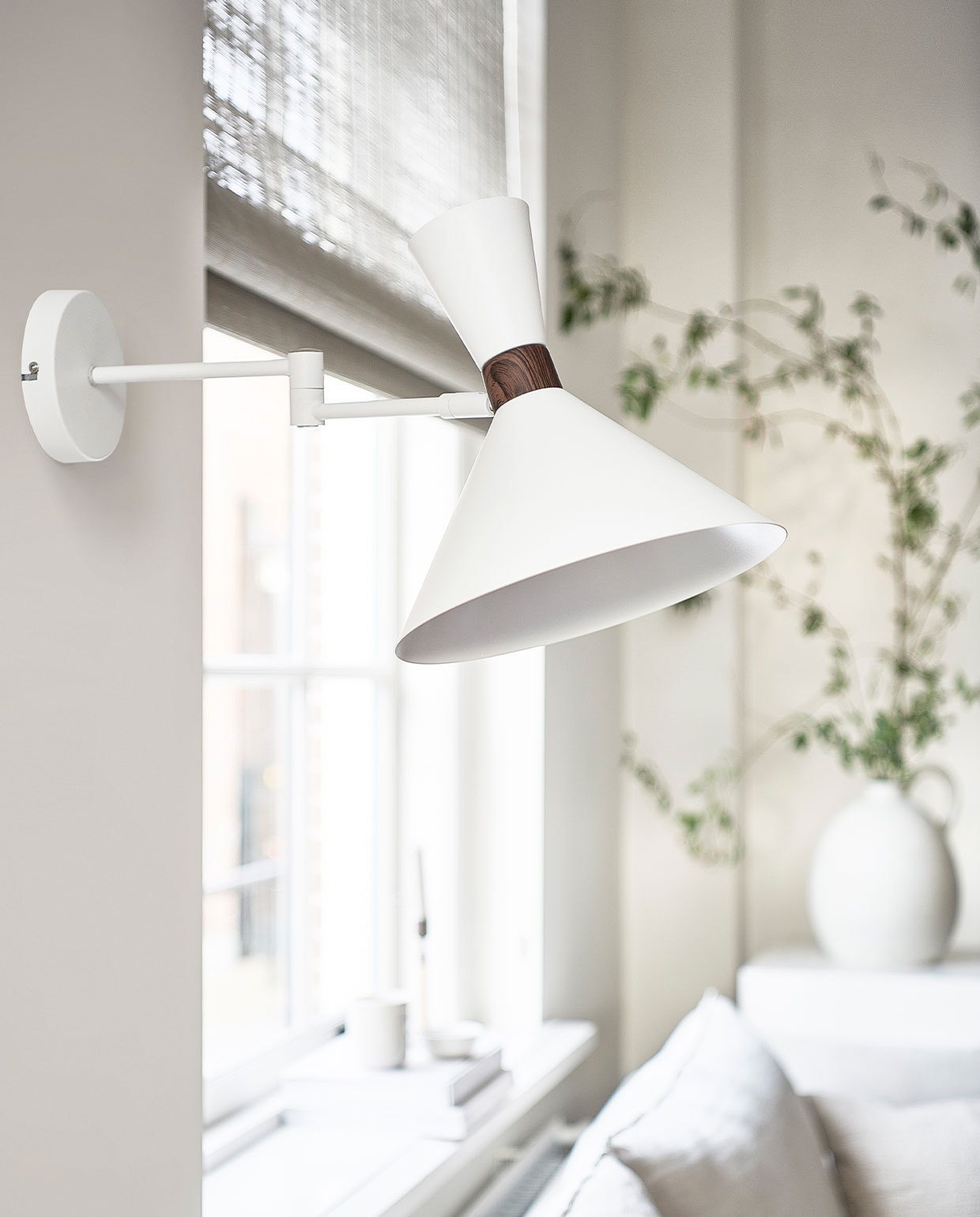 Matte zandgrijze metalen wandlamp Hoodies, 25x25x50,5 cm (ook verkrijgbaar in matzwart) | M.m.v. ikea.nl (bank Söderhamn), bemz.com (linnen hoes voor de bank), zarahome.com (vaas), bauwerkcolour.com (muurverf kleur Mykonos), nature-deco.com (raamdecoratie). Overig privébezit. vtwonen 3-2022 | productie Tanja Saarberg | styling Kim van Rossenberg  | fotografie Sjoerd Eickmans