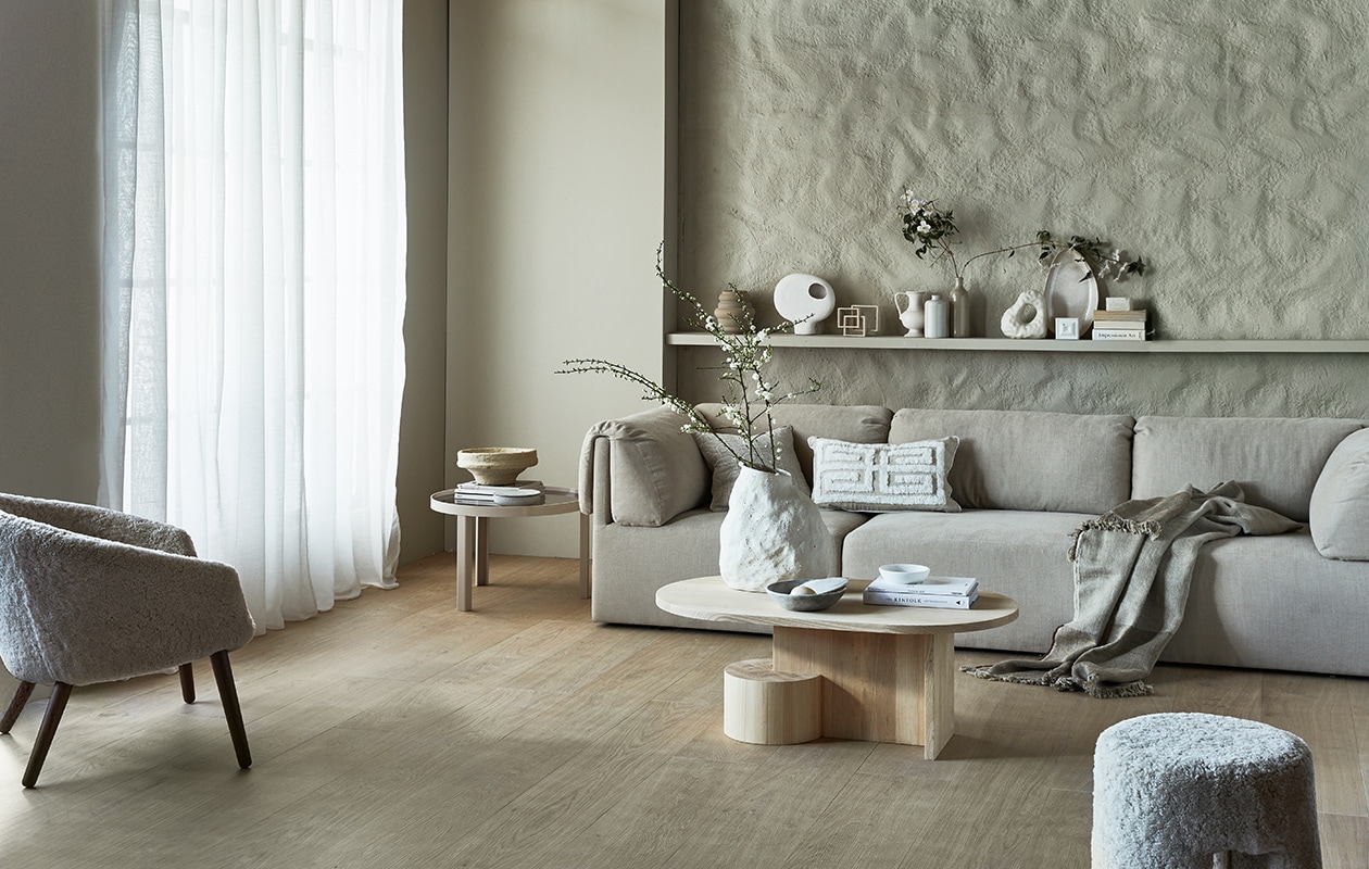 Gordijn Frost, wit, half transparant, met plooi, 270×140 cm (hxb) € 42,99.M.m.v. karwei.nl (muurverf Warm Grey van vtwonen), vtwonen.nl (vloertegels Blancs Naturel van vtwonen, salontafel Insert van Ferm Living, vaas Vulca van Ferm Living, bijzettafel Cedric van Fest Amsterdam, boekensteun van Hay, zandkleurige geribbelde vaas Bloomingville, witte pot met deksel van Broste Copenhagen), nordicnew.nl (bank van Gubi), designtales.nl (fauteuil en poef van Fredericia), luxurybynature.nl (kussens, vaas met rond gat), studio-yen.com (sculptuur van vierkanten), weldaad.com (marmeren schalen en papier-maché schaal), couleurlocale.eu (plaid), hm.com (schaal op plank), neeflouis.nl (vintage flesvazen). vtwonen 07-2021  | Productie Tanja Saarberg | Styling Cleo Scheulderman | Fotografie Jeroen van der Spek