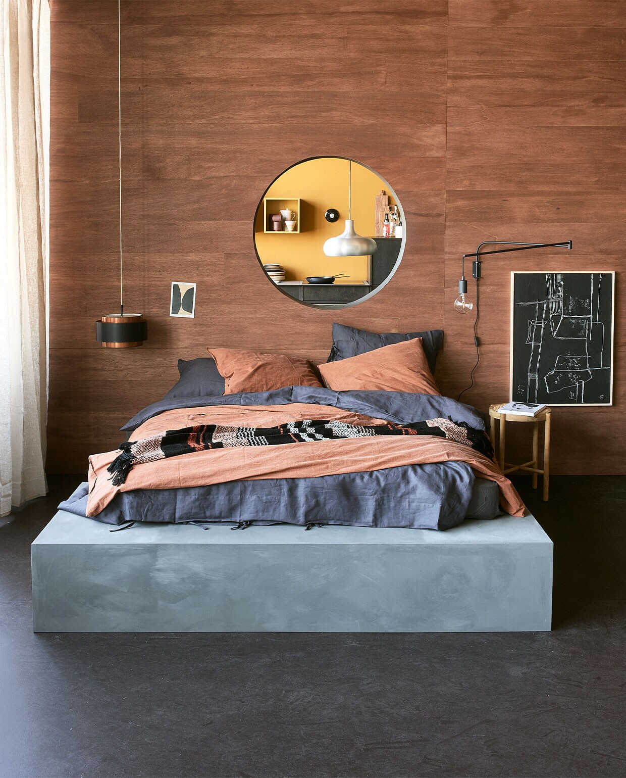 Bed op maat gemaakt en geverfd met kalkverf Blue Stone van Pure &amp; Original. De natte verf werd met een doek bewerkt voor dit effect. Steenrood dekbed­overtrek Natural Stone van vtwonen, 200×220 cm € 109,95, gestreept plaid van Malagoon, 150×125 cm € 59,95, wandlamp Line van Trio € 39,95 (vtwonen.nl). Blauw dekbedovertrek Puderviva, 200×200 cm € 69,95, linnen gordijnen Dytag, 145×300 cm, set van 2 € 59,95 (ikea.nl). Hanglamp € 95,- (neeflouis.nl). Zwart kunstwerk Brutalism € 279,-, kruk met webbing zitting € 139,- (hkliving.nl). vtwonen 10-2021 | Styling Fietje Bruijn | Fotografie Dennis Brandsma