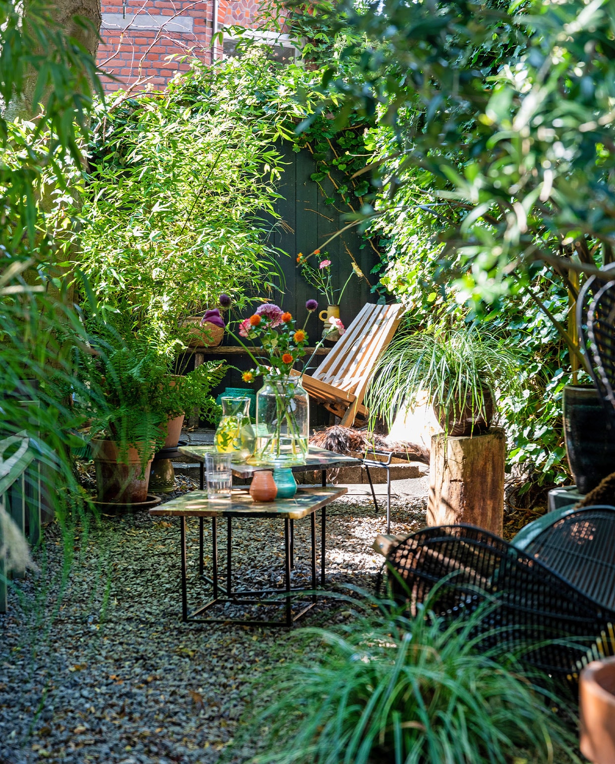 Bijzettafels en waterkaraf vintage vondsten, buitenkaarsen Bolsius, vaas vtwonen. Boomstam uit het bos. Houten ligstoel Weltevree. Terracotta potten en planten tuincentrum. Vachten Vacht van Vilt, stoel HKliving. -vtwonen TUIN special 3 | styling Theo-Bert Pot, Jelle Van de Schoor | fotografie Theo-Bert Pot