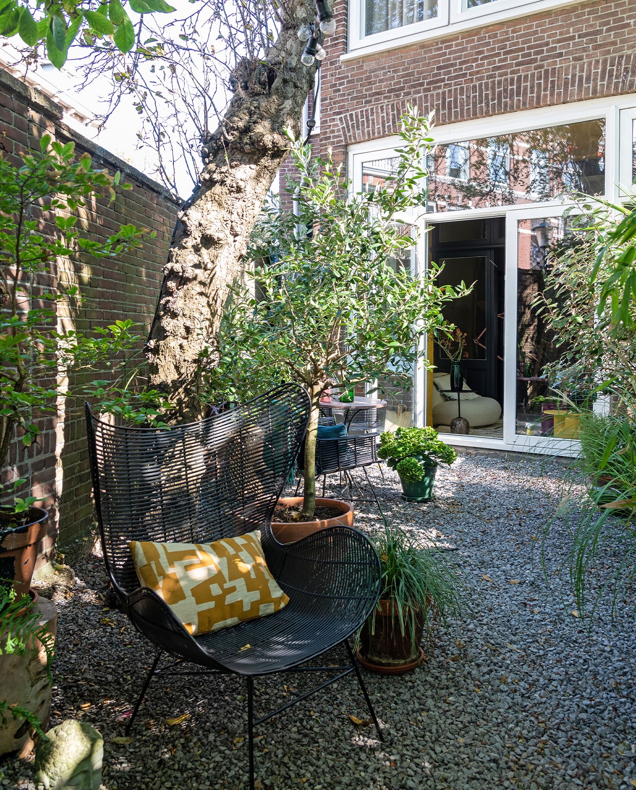 Stoel HKliving, kussen laten maken met stof van Dedar, terracotta potten tuincentrum. Op de grond grijs basalt split van verschillende grootte. vtwonen TUIN special 3 | Styling Theo-Bert Pot, Jelle Van de Schoor | fotografie Theo-Bert Pot | tekst Cathelijne van Wingerden