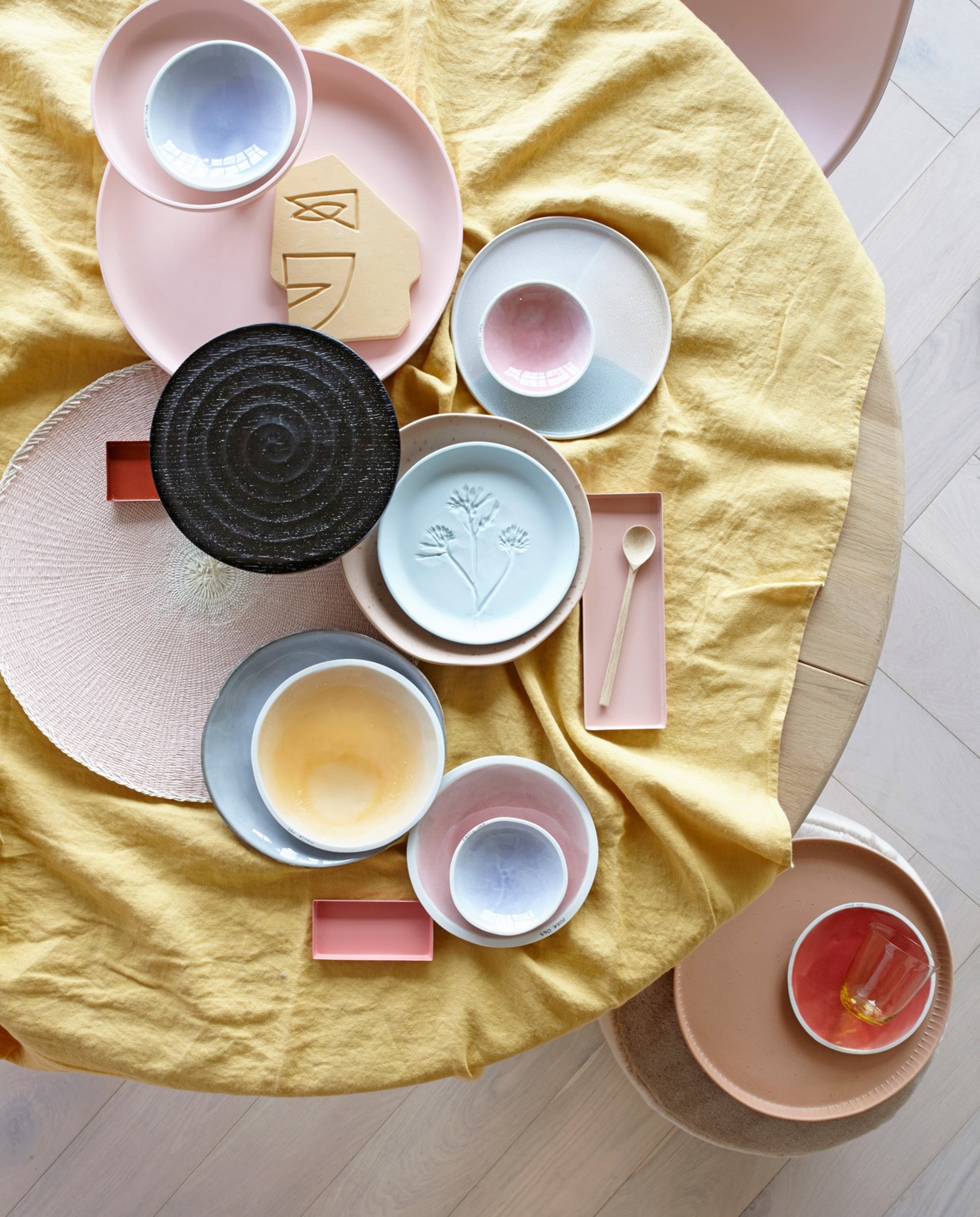 Parket visgraat eiken wit geolied van vtwonen (karwei.nl). Ronde eikenhouten eettafel, roze eetkamerstoel (coosdewitwonen.nl). Geel linnen tafelkleed (letoile.store). Roze etagère (loods5.nl/design). Schaaltjes XS in blauw en roze, S in blauw, M in geel, roze en rood (studioharmenelke.nl). Ornament gezicht, rond bord met opstaande rand, rond terra dienblad (hkliving.nl). Zwarte houten etagère (paviljoennoord.com). Roze placemat (klevering.nl). Niet perfect rond bord met spikkeltjes, vergrijsd blauw bord (loods5.nl). Lichtblauw bord van keramiek met bloemprint (letoile.store). Rechthoekige schaaltjes in verschillende tinten roze, geel glas (hm.com). Houten lepel (restored.nl). Roze fluwelen poef (covanderhorst.nl). vtwonen 06-2019 | styling Danielle Verheul | fotografie Petra Steenkamer