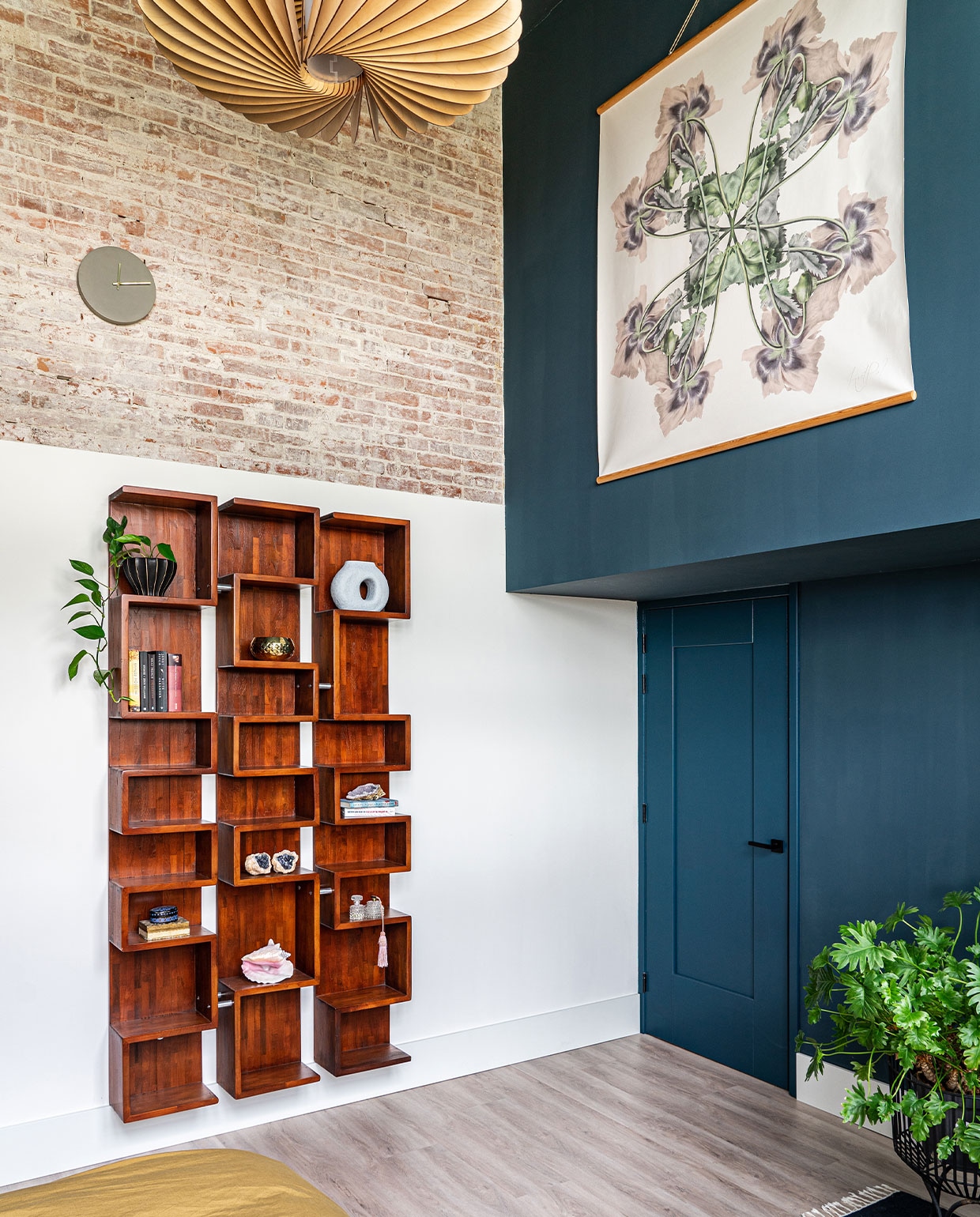 Muurverf Steel Blue van Pure & Original. Kast vintage, kunstwerk Hanneke van de Pol, kleed Ferm Living, lamp Werp, plantenstandaard Urban Nature Culture. In de kast blauwe vaas van HKliving, gouden kom van Broste Copenhagen, overig onbekend. vtwonen 01-2022 | styling Kundertje Hamstra, Iris Floor | fotografie Iris Floor