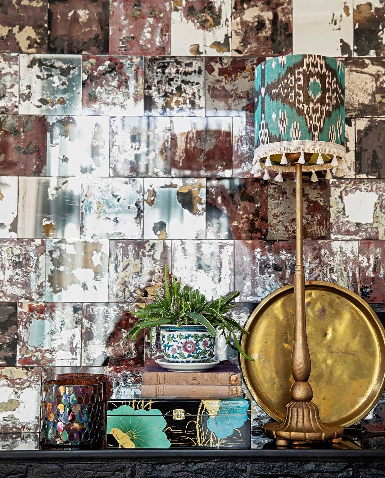 Spiegeltegels Praxis zelf bewerkt voor een verweerd effect, lampvoet kringloop zelf goud gespoten, kap van ikat-stof via Capsicum Amsterdam, waxinelichthouder via Bij Lokaal, doosje cadeau, plantenpot en gouden tray Hippe Kringloop. vtwonen 04-2021 | productie en styling Ilona Jongepier | fotografie Dana van Leeuwen | tekst Anna van der Heijden