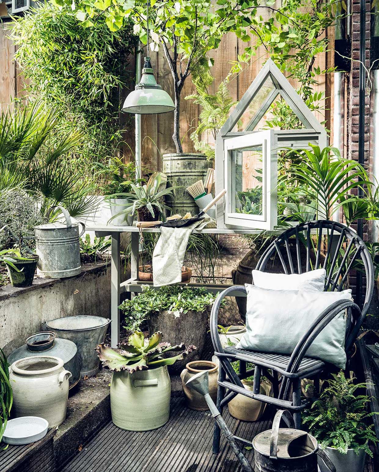 Grijze gieter, groene lamp, emmer (Burbri Antiek). Kunstboom, groene ton, kunstplant, mintgroene pot (De Weldaad). Bezem (Mijn Stijl). Borstel (HAY). Groene theedoek (Dille &amp; Kamille). Tafel en kleine kas (Combitex). Stoel (Household Hardware) Kussens, onderzetter grijze pot (vtwonen.nl). Diverse witte potten (Linda’s hoekje). Stalen vaas (Raw Materials). vtwonen 08-2017 | Fotografie Sjoerd Eickmans | Styling Liza Wassenaar