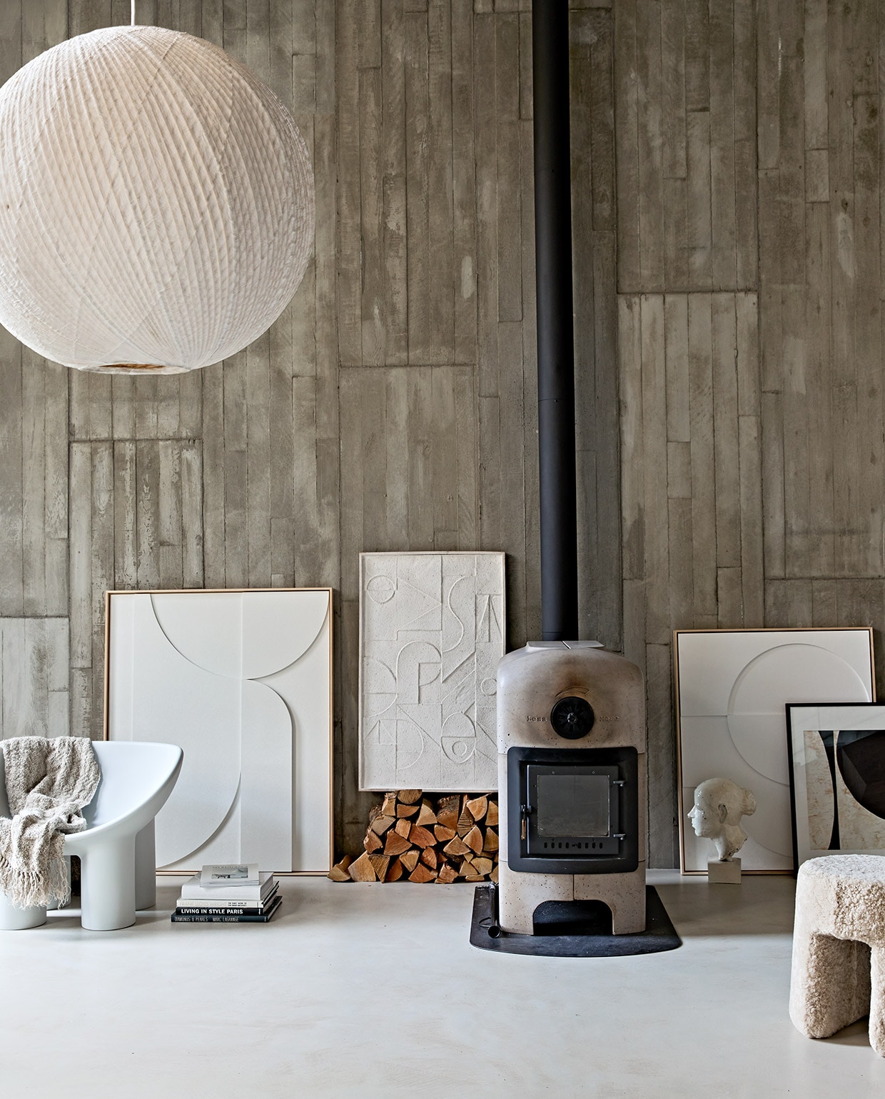 Betonnen houtkachel vanaf € 6500,-(dekleinenvanhoff.nl). Grijze kunststof stoel Roly Poly van Driade € 410,- (kmpkantoormeubilair.nl). Papieren-bamboe hanglamp Bali, 80 cm (Ø) € 695,-, grote kunstlijst met wit reliëf 123x100x4 cm (lxbxd) € 629,-, kunstlijst wit rechts naast de kachel, 83x62x4 cm (lxbxd) € 449,-, linnen plaid 130×170 cm € 169,95 (hkliving.nl). Lijst met reliëfkunst op stapel hout € 199,- (urbannatureculture.nl). Zwart-witte collage, ingelijst, prijs op aanvraag (artinreturn.nl). Wit object vrouwenhoofd (vintagehoarder.com). Poef Sequoia bekleed met schapenvacht van Fredericia, 40×42 cm (Øxh) vanaf € 865,-(designtales.nl). vtwonen 02-2021 | Styling Cleo Scheulderman | Fotografie Jeroen van der Spek