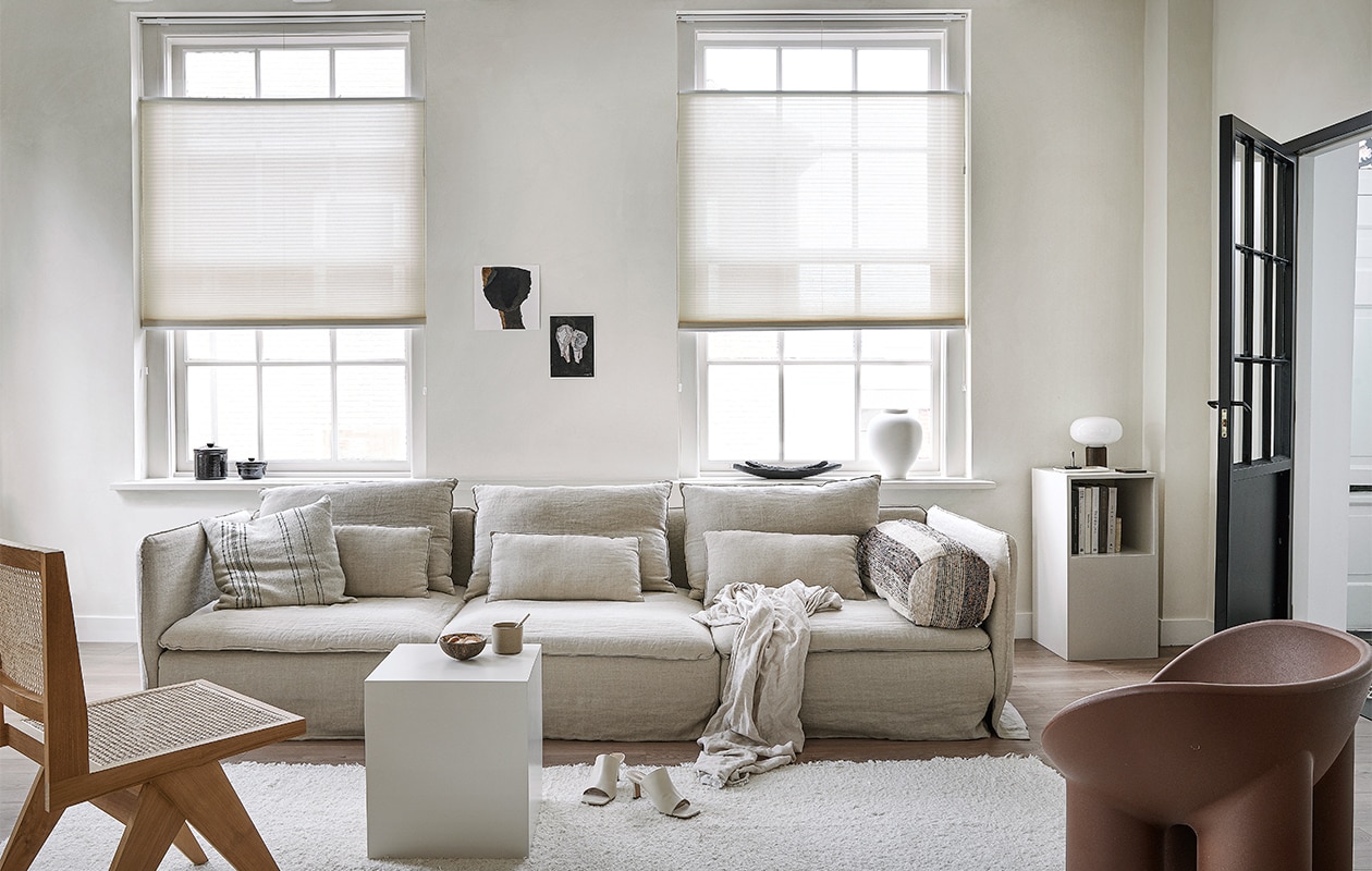 Lichtdoorlatend plisségordijn in kleur Linnenbeige (18074) vanaf € 204,39.m.m.v. karwei.nl (vtwonen EVC vloer in kleur Oat), ikea.nl (bank Söderhamn), bemz.com (linnen bankhoes), zarahome.com (linnen plaid, zwarte schalen, witte vaas), stories.com (schoenen), aimetestudio.com (houten stoel Pierre), puurdesign.nu (bruine stoel Roly Poly van Driade), casagitane.com (rond kussen Tronc), newworks.dk (tafellamp), bauwerkcolour.com (muurverf in kleur Mykonos). Overig privébezit. vtwonen 09-2021 | productie Tanja Saarberg | styling kim van Rossenberg | fotografie  Peggy Janssen\n