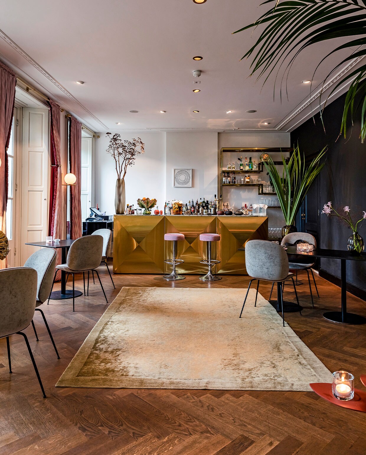 Eyecatcher van de Voltaire Bar is de op maat gemaakte bar van messing en marmer. De Beetle chair, een ontwerp van GamFratesi voor Gubi, is op veel plekken in het hotel terug te zien, in verschillende kleuren. Het schilderij tegen de achterwand is van ‘stylemeister’ San Ming. vtwonen hotels bijlage 13-2020 | Fotografie Ernie Enkelaar  | Tekst Roos Stalpers en Fee van ’t Veen