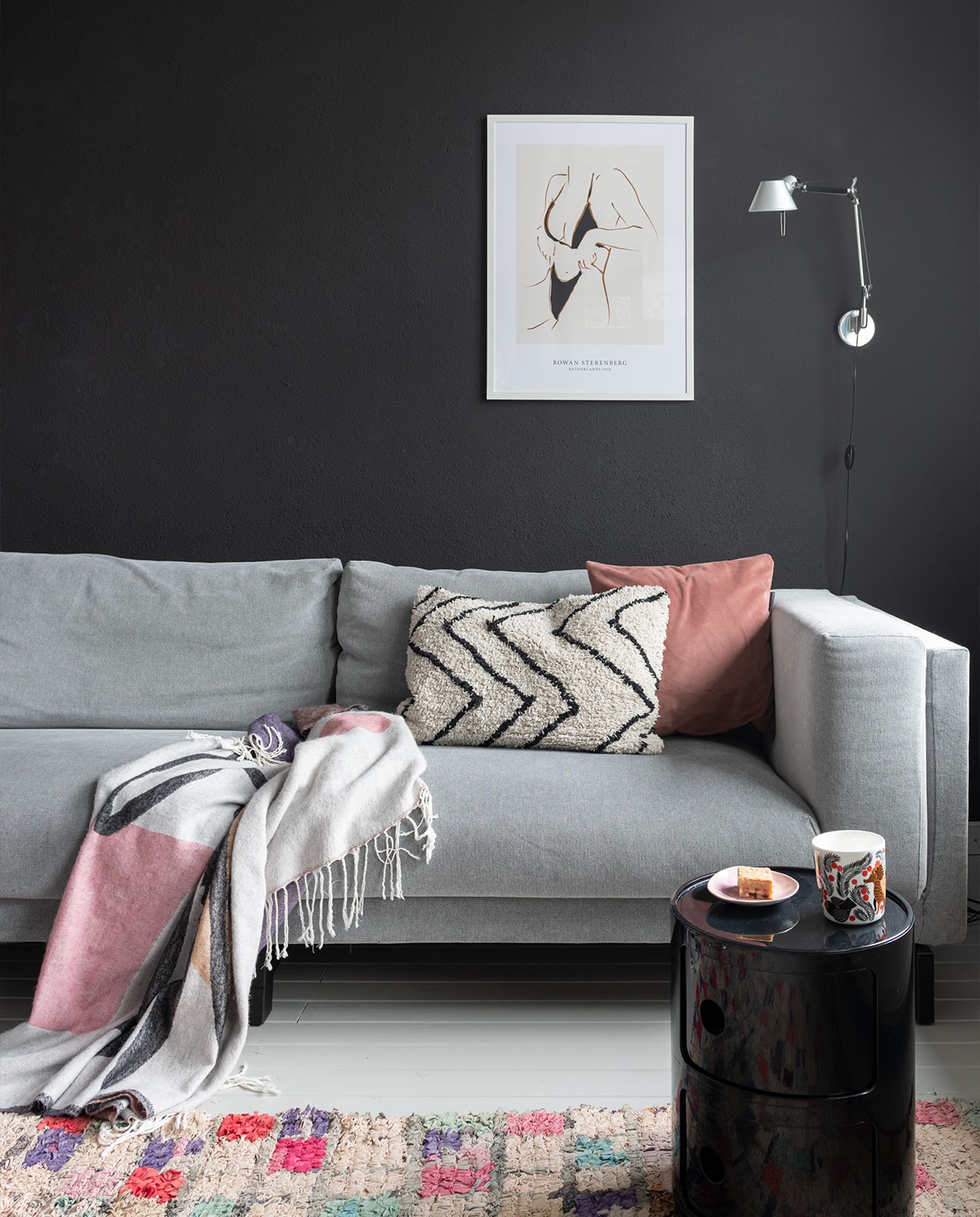 Bank Ikea, zwart kastje Componibili van Kartell. Hanglamp en beige kussen HKliving, wandlamp Tolomeo van Artemide. Vintage Boucherouite kleed van Trendcarpet, roze kussen Particolare, plaid Sissy-Boy Homeland. Glaswerk Iittala, zwarte kandelaar Normann Copenhagen, spiegel Kwantum. Muurkleur Raaf van Histor. Schuifdeuren via vhdeuren.nl. Houten vloer gelakt met NyLo topcoat kleur 7044. vtwonen 13-2021 | styling Sharon Roest | fotografie Caroline Martinot | tekst Monique van der Pauw