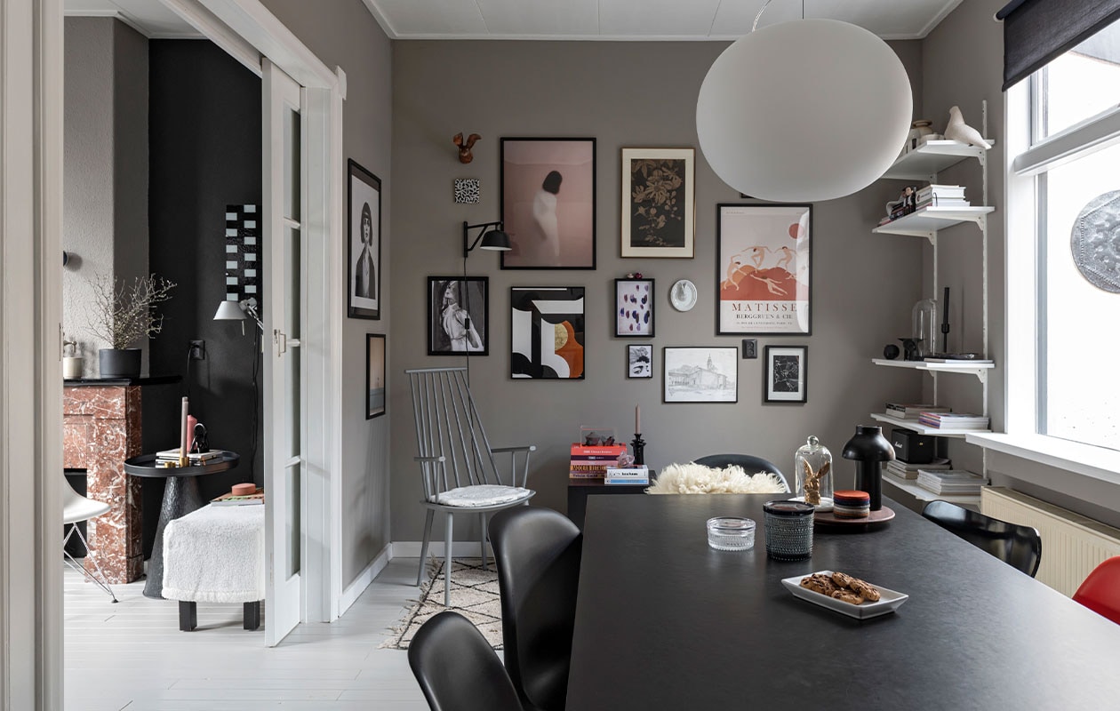 Stoel J110, wandlamp Hay, kussen zelfgemaakt. Hanglamp Glo Ball S2 van Flos. Vloerkleed en vitrinekist HKliving, minivaasjes Hella Duijs. Zwarte bijzetter Westwing, kandelaar Day. Konijn Vintage Fever, onderzetters Nio &amp; Elva. Potten Iittala. Wandlamp Ambit van Muuto. Kunst v.l.n.r.: print vrouw Mia Wallace via Ruben Ireland, H&amp;M. Haas papier-maché Babettes Wereld, tegel Studio Job van Koninklijke Tichelaar, posters vrouw en print druppel en gezicht Juniqe. Minivaasjes op lijst van bevriende kunstenaar. Print roze vrouw Gurille Design, grafische print Part 2 Terra van Atelier Andrea. Passiebloem van Anton Pieck uit ouderlijk huis. Keramieken hazenkop Des Pots. Print Matisse Pstr studio. Tekening Zwitserse kerk door plaatselijke kunstenaar. Print Rechtszaak van Studio Abeelen. Muurverf Authentic Grey van Flexa. Eettafel en zwarte lamp Hay,. Konijn Vintage Fever. Panton Chairs van Vitra, vacht sheepy.cc. vtwonen 13-2021 | styling Sharon Roest | fotografie Caroline Martinot