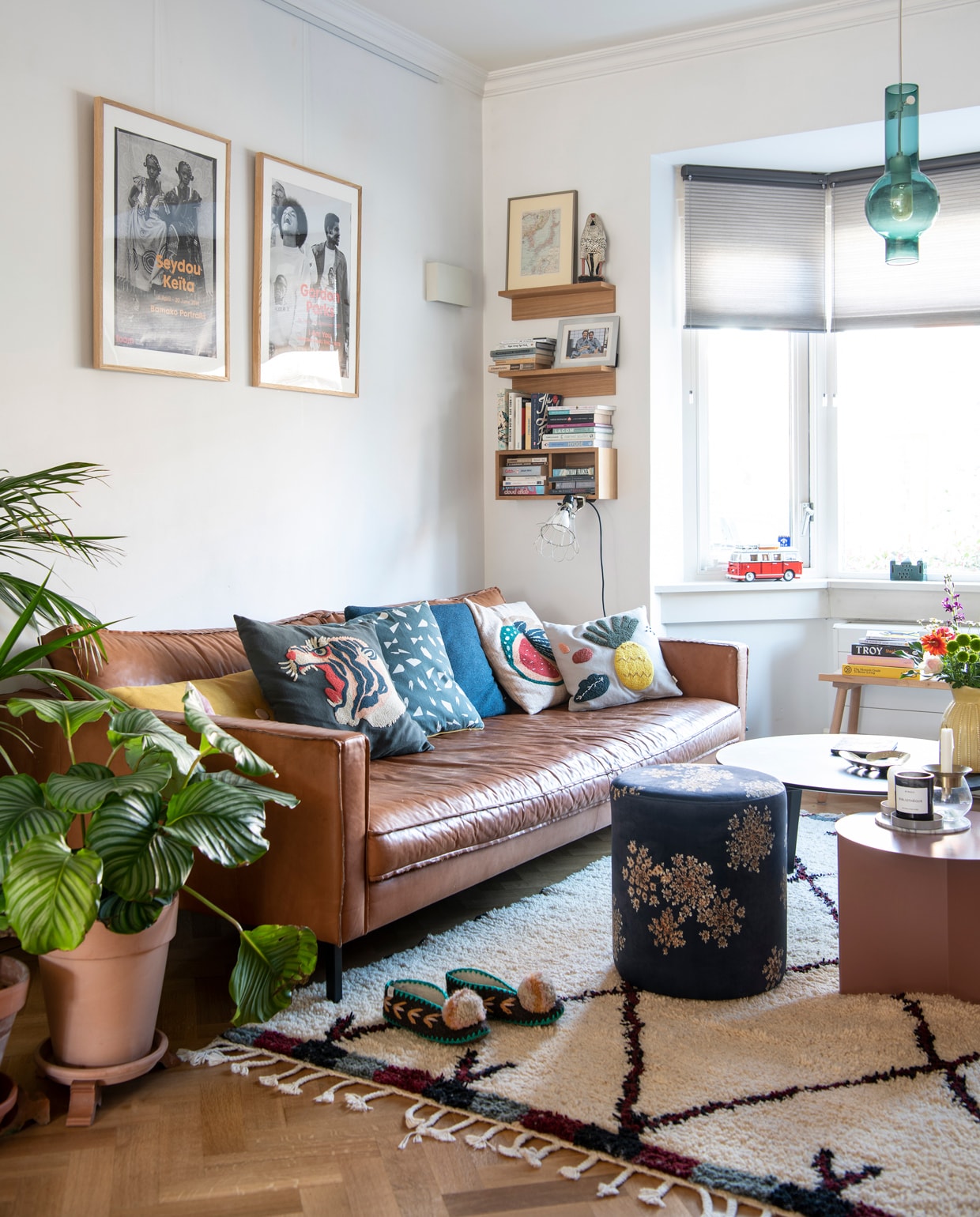Bank Loods 5. Kussens: gele en blauwe Dot van Hay, met tijger- en meloenprint Sissy-Boy, met grafisch dessin Ferm Living, met ananasprint &amp;klevering. Vloerkleed The Weavery Shop, poef Essenza Home. Bijzettafel Slit en salontafel CPH Deux 250 van Hay. Geurkaars Bibliothèque van Byredo via Skins Cosmetics. Hanglamp Felice home of brands, raambekleding van Luxaflex via Vonk &amp; Vloer. Boekenplanken Muji, klemspot Merci Parijs. Ingelijste prints aan de muur Foam. Slippers Give a pom. Beeld vogel souvenir uit Nigeria van Lindsays vader, ernaast een ingelijste plattegrond van Etsy. Wandlamp hing al in het huis, bank in erker van Hay voor Ikea. vtwonen 13-2021 | Productie Insidehomepage | Styling Kim Timmerman | Fotografie Louis Lemaire | Tekst Inge van Lieshout | Tekstbewerking Mariska Keus