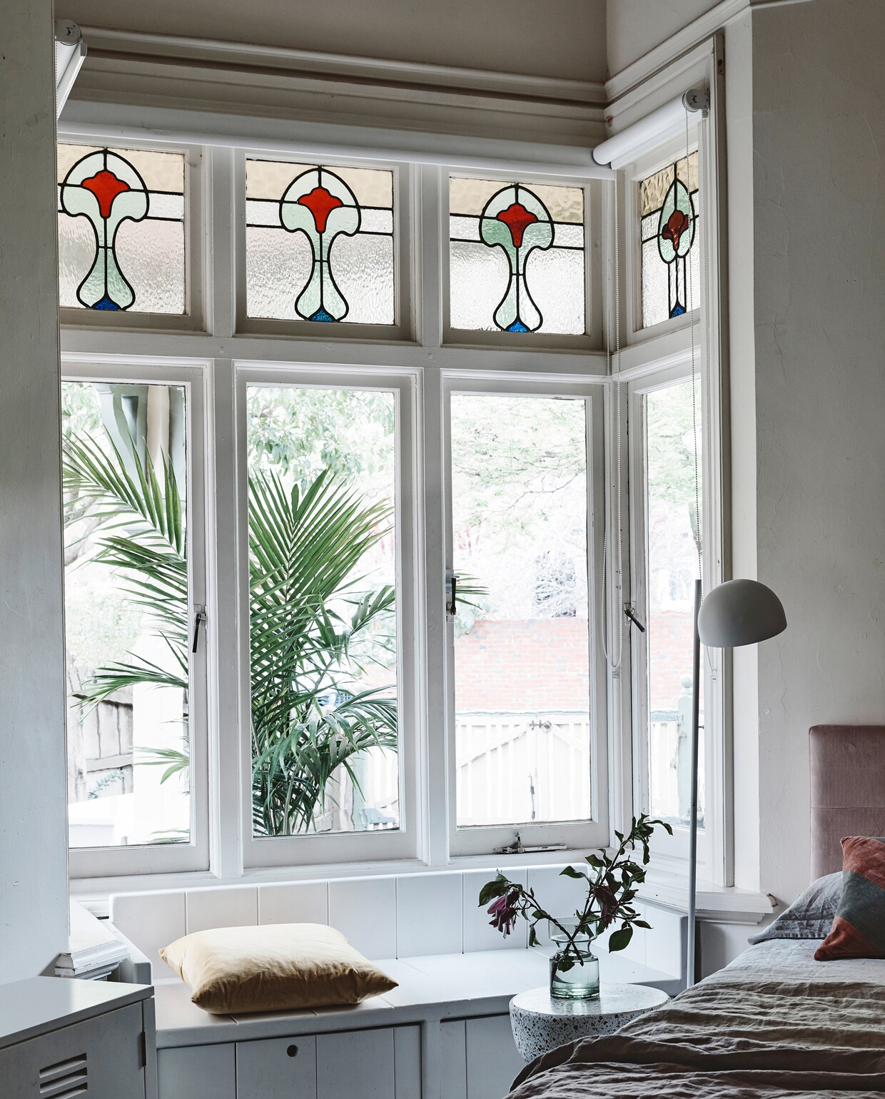 In de kamer van Nina maakte Hans zelf een bank voor de nis. ‘Vroeger zat ze hier vaak met een boek, nu met haar iPhone.’ Fluwelen bedhoofd en beddengoed van House of Orange. Bijzettafel, lamp en gestreept kussen van HK Living. De badjas is een souvenir van Bali. fotografie Derek Swalwell | tekst Mariska Keus | styling Rachel Vigor