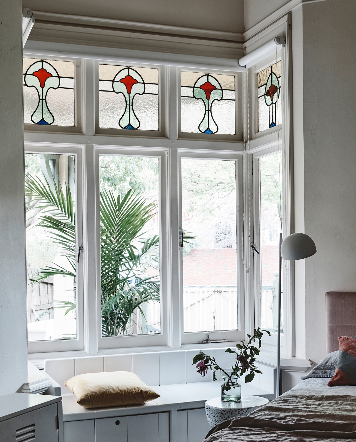 In de kamer van Nina maakte Hans zelf een bank voor de nis. ‘Vroeger zat ze hier vaak met een boek, nu met haar iPhone.’ Fluwelen bedhoofd en beddengoed van House of Orange. Bijzettafel, lamp en gestreept kussen van HK Living. De badjas is een souvenir van Bali. vtwonen 08-2018 | fotografie Derek Swalwell | styling Rachel Vigor