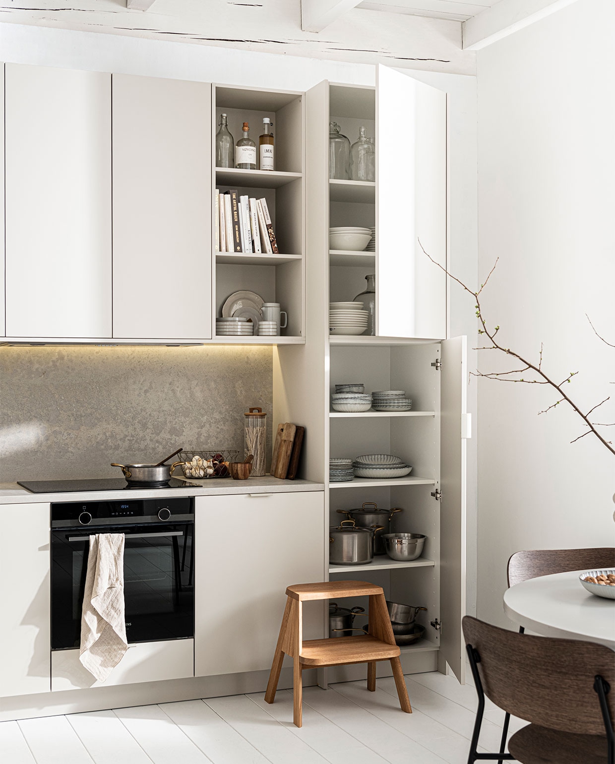 Keuken Basic Greige zoals getoond, exclusief accessoires € 22.500,- | M.m.v. menuspace.com (stoel Co), com-anders.nl (tafel), vtwonen.nl (servies van Serax, pannen van Sambonet), thefinestore.com (kruk Butler van Hay, draadmand, theepot en borden van Hasami), vtwonen.nl (servies en theedoek van vtwonen), zarahome.com (opbergpot, vijzel). Overig privébezit. vtwonen 12-2021 | Productie Tanja Saarberg | Styling Kim van Rossenberg | Fotografie  Sjoerd Eickmans