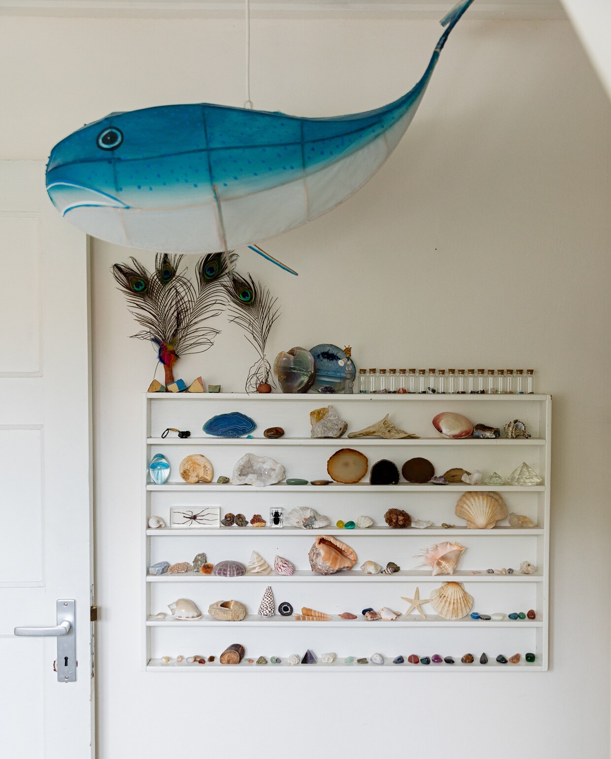 Papieren walvislamp Petit Pan. Letterbak rommelmarkt. Verzameling mineralen, schelpen en fossielen onder meer van Steen en Been, rommelmarkten, kringloopwinkels en vakanties naar Frankrijk, Ibiza en Thailand. Glazen flesjes met dop Dille &amp; Kamille. vtwonen 13-2021 | Styling Ilona Jongepier | Fotografie Dana van Leeuwen | Haar &amp; make-up Djolien de Kreij | Tekst Eveline Stoel