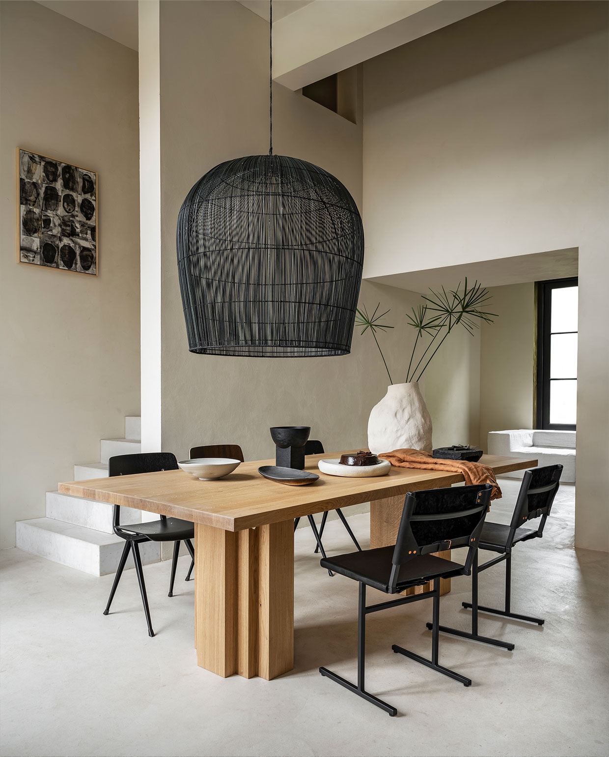 Eikenhouten tafel Brut van Aad Bos, 240x110x75 cm (lxbxh) € 4300,- (mokkoamsterdam.com). Rieten lamp van Ay IIluminate, 95 cm (h) € 1750,-, stoelen Result van Hay € 269,-, vaas Vulca van Ferm Living € 199,- (vtwonen.nl). Stoelen van staal en leer € 490,- (wdstck.eu). Handgemaakte schalen in verschillende vormen vanaf € 75,- (marjokedeheer.com). Houten schaal op voet € 49,95 (urbannatureculture.com). Schilderij van Marlies Hoevers, prijs op aanvraag (hoeversid.com). Bank met linnen hoes, zijkant 120x120x60 cm (lxbxh), tussen-stuk 120x90x60 cm (lxbxh), verkrijgbaar december ’21, per element vanaf € 850,- (10dayslifestyle.nl). vtwonen 10-2021 | styling Marianne Luning | fotografie Stan Koolen