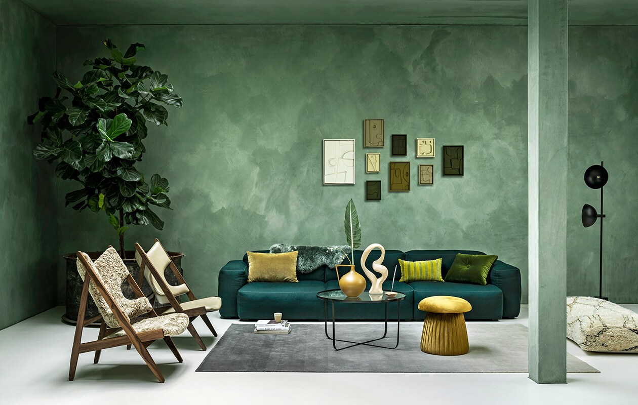 Wollen elementenbank van Hay, 74,6×95,5 cm (dxb), per element vanaf € 2129,-, schapenvacht € 69,- (eijerkamp.nl). Vloerkleed 200×300 cm, per m2, € 900,-, leren Knitting stoel van Menu vanaf € 2595,- (kasstoor.nl). Schapenwollen Knitting stoel van Menu vanaf € 2595,- (designtales.nl). Salontafel van glas en staal van Bloomingville € 269,-, velours poef van Bloomingville € 111,20, mosgroen velours kussen van Hay € 79,-, vaas van HKliving € 99,90, wit object van Bloomingville € 34,20 (vtwonen.nl). Berber zitpoef € 319,- (elramlahamra.nl). Metalen vloerlamp Handvark € 585,- (goeds.nl). Kunst aan de muur van Edith Beurskens vanaf € 130,-(edithbeurskens.com). Okergeel velours kussen € 29,95, gestreept velours kussen € 32,95, zandkleurige beker € 6,- (hkliving.nl). Waxinelichthouder € 39,-, wierook € 20,- (sukha.nl). Kalkverf Lagune, per liter € 48,- (cartecolori-dialma.nl). Overig privébezit. vtwonen 01-2021 | styling Marianne Luning | fotografie Stan Koolen