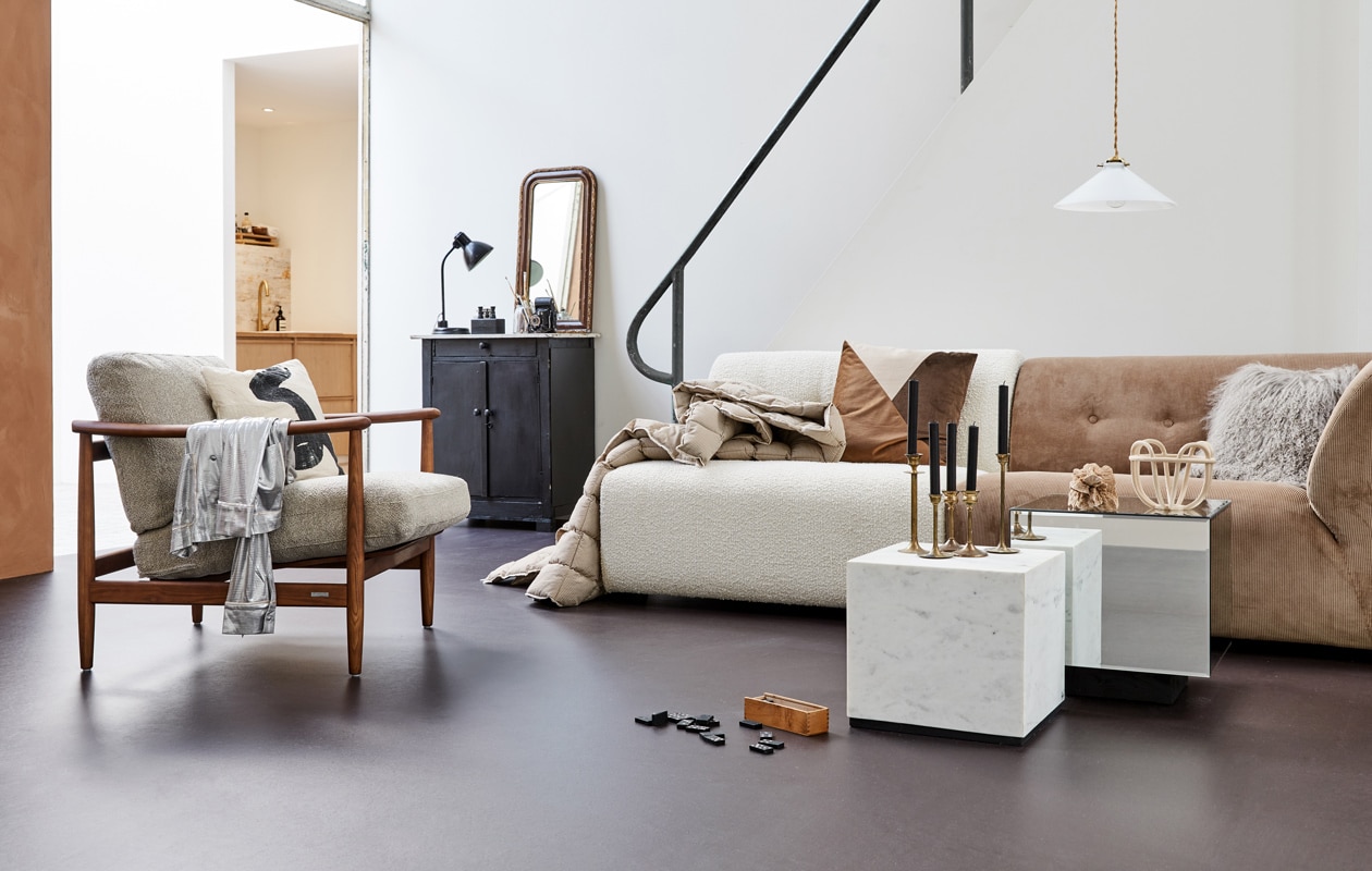 M.m.v. hkliving.nl (bank bestaande uit twee losse delen, marmeren salontafel, salontafel met spiegels), vtwonen.nl (fauteuil van Pols Potten, kussens op de bank, kussen in fauteuil), jolandelijkdewebshop.nl (kast, spiegel, bureaulamp, hanglamp, dominospel, theaterkijker, camera), fortuneflea.com (gouden kandelaars), littledreamers.nl (dekbed met streep), karwei.nl (schaal op tafel). Overig privébezit. vtwonen 01-2022 | Productie Tanja Saarberg | Styling Marlies Does | Fotografie Bart Brussee | Assistentie Judie Jonker
