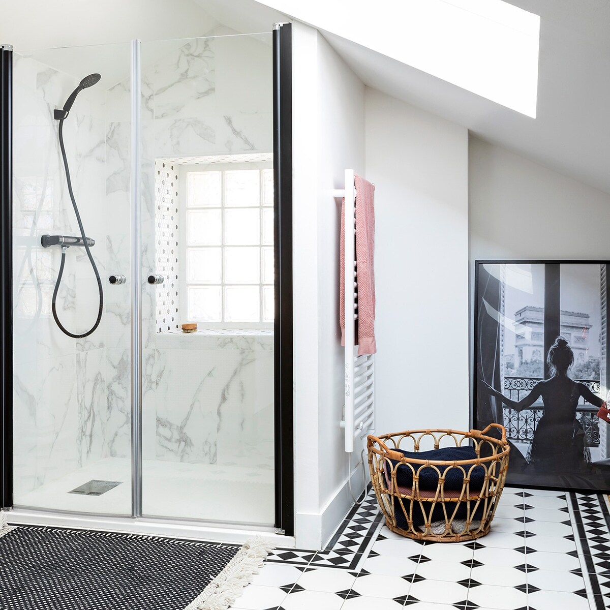De stoffige zolder werd getransformeerd tot ouderslaapkamer met inloopbadkamer. Het marmer in de douche is van Leroy Merlin. Mand Ikea. vtwonen special zomerhuizen 07-2021 | Productie en tekst Anne-Catherine Scoffoni | Fotografie Pauline Legoff\n\nvtwonen special zomerhuizen 07-2021 | badkamer met zwart witte tegels