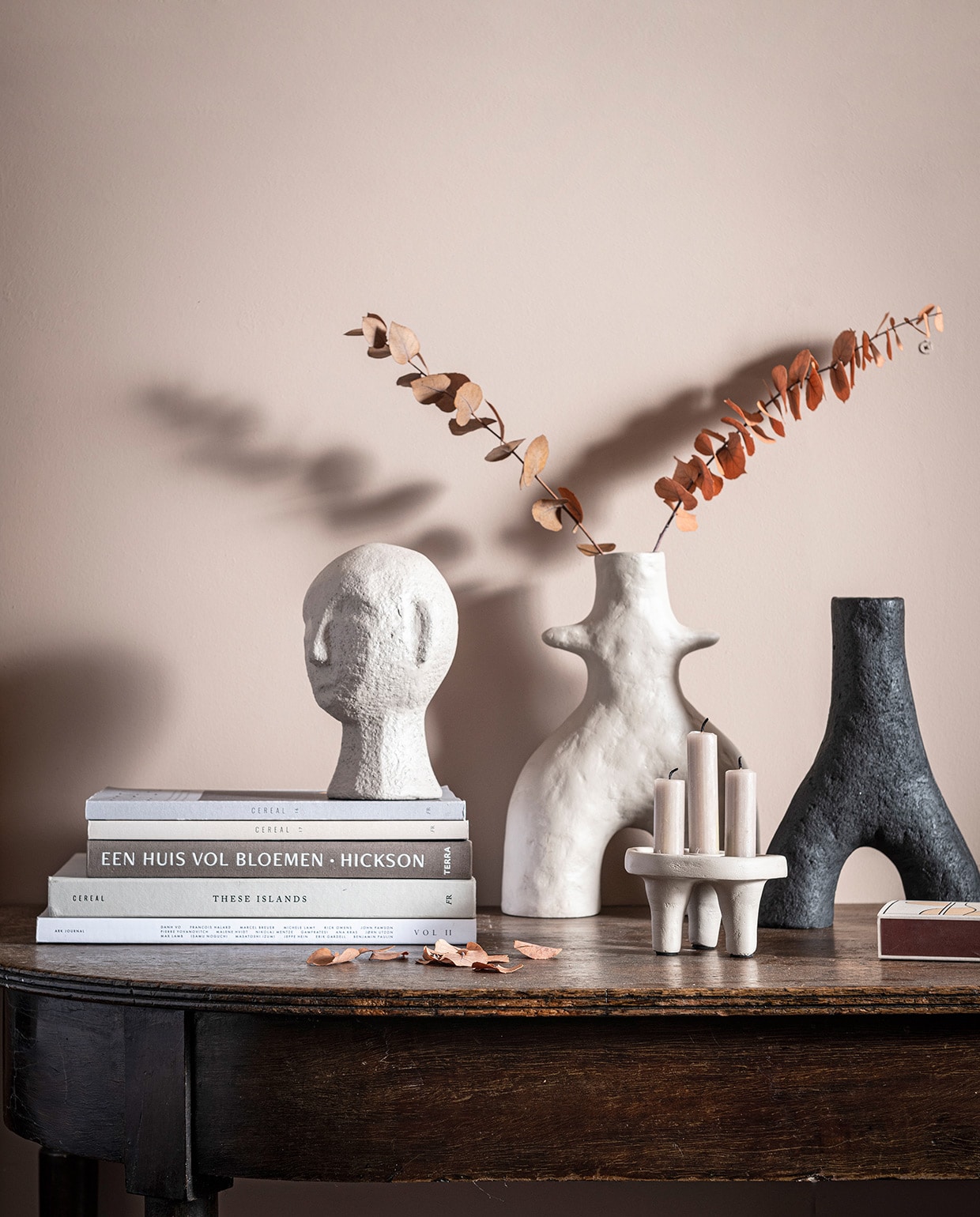 V.l.n.r. Zandkleurige sculptuurkop gemaakt van ecomix, in maat S, 13,5×12,5×20 cm (bxdxh) € 34,95. Zandkleurige vaas Twig gemaakt van ecomix, in maat M, 20x8x29 cm (bxdxh) € 44,95. Zandkleurige kandelaar met ruimte voor 3 kaarsen gemaakt van ecomix, 12x12x7 cm (bxdxh) € 16,95. Zwarte vaas Twig gemaakt van ecomix, in maat S, 18x6x25 cm (bxdxh) € 39,95. Tafel en boeken privébezit. vtwonen 05-2021 | productie Tanja Saarberg | styling Kim van Rossenberg | fotografie Sjoerd Eickmans