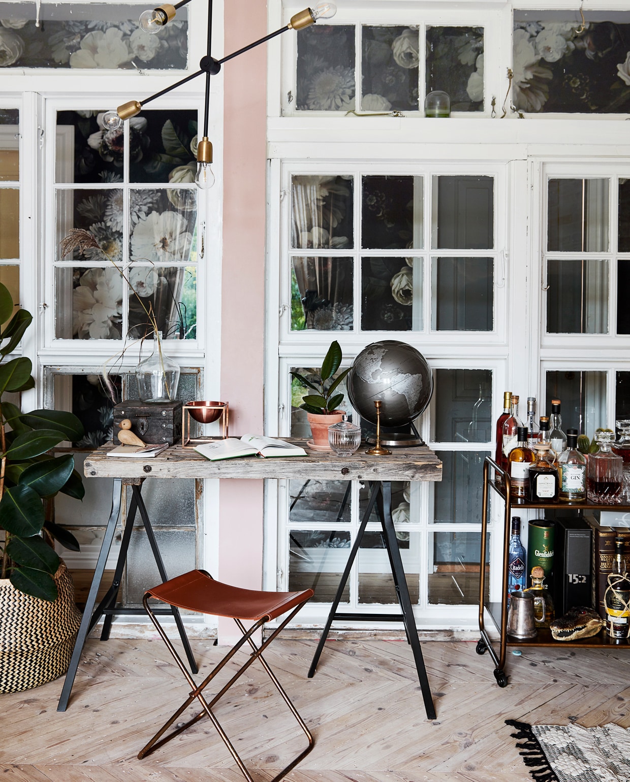 Wand naar de hal vintage ramen Genbyg. Bloemenbehang Ellie Cashman. Bureau van Ikea-schragen met vintage blad. Kruk Broste Copenhagen. Lamp House Doctor. Serveerwagen vintage. vtwonen 12-2021 | Productie Living Stories |  Styling en tekst Pia Olsen | Fotografie Stine Christiansen | Tekstbewerking Christine van der Hoff