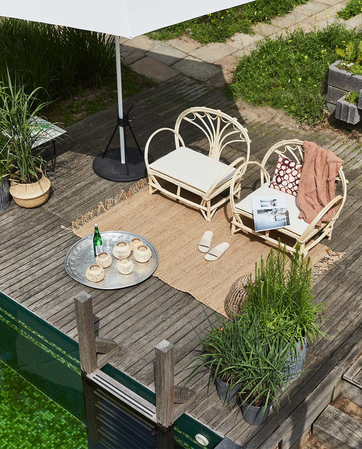 Handgemaakte loungestoelen uit Essaouira, Marokko, en natuurlijk volop zon: dat zijn de ingrediënten voor een vakantie in tropische sferen. Geef er een eigen draai aan met aluminium dienblad, vintage, 75 tot 110 cm (Ø) (householdhardware.nl). Coconut windlicht uit Bali, 13 cm (Ø), slippers soortgelijk bij Sukha (sukha.nl). Plaid 130×170 cm, vloerkleed 12×180 cm (hkliving.nl). Mand Flädis (ikea.com). Aluminium parasol, 200×200 cm, parasolvoet (extravert.nl). Overig privébezit. vtwonen special tuin 03 2021 | styling Fietje Bruijn | fotografie Alexander van Berge