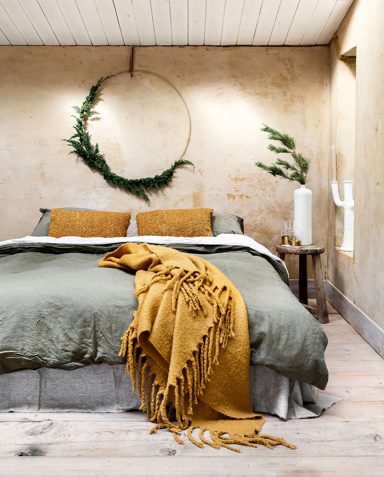 Metalen ring € 44,35, plaid € 94,50 (bol.com). Linnen dekbedovertrek groen, 240×220 cm € 99,-, linnen dekbedovertrek wit, 240×220 cm € 99,- (hm.com). Bouclé kussens, per stuk € 22,95 (karwei.nl). Karaf van Serax € 28,05, glas van Serax € 18,25 (vtwonen.nl). Overig privébezit. vtwonen 12-2021 | styling Moniek Visser | fotografie Stan Koolen | assistentie Sanne Kiesling
