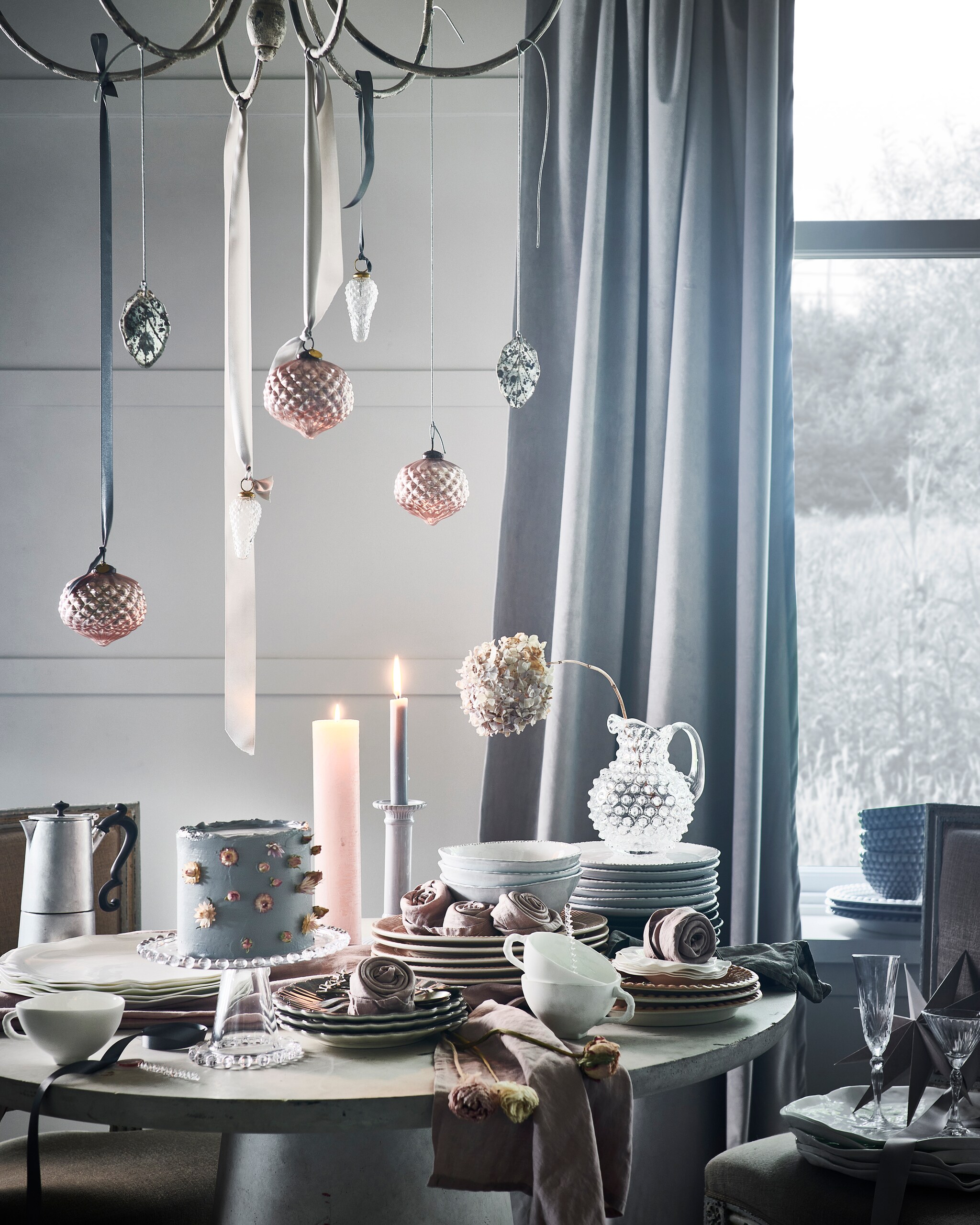 Taart, prijs op aanvraag (stickyflour.nl). Bloemen, prijs op aanvraag (tuinvanjudith.wordpress.com). Tafel € 439,- (basiclabel.nl). Antieke stoelen, per stuk (pietjonker.nl). Kroonluchter € 300,-, koffiepot € 70,-, glazen karaf € 70,- (paviljoennoord.com). Witte borden en kommen in organische vorm, per stuk vanaf € 19,75, wit porseleinen kopjes, per stuk € 24,-, zilveren gebaksvorken, per stuk € 8,50 (serax.com). Glazen plateau op voet € 14,99, witte kandelaar € 17,99, roze servetten, set van 2 € 9,99, witte terracotta kommen en borden met schulprand, per stuk vanaf € 7,99 (hm.com). Grijze borden in bloemvorm, per stuk € 22,50, roze borden met reliëfrand, per stuk € 29,50, roze ovale borden met schulprand, per stuk € 20,95, grijze ovale schalen met schulprand, per stuk € 49,50, grijze kommen met schulprand, per stuk € 32,50 (zwaanzinnig.shop). Roze kerstballen, per stuk € 4,99, zilveren theelepels met vogel, per stuk € 4,99, theelepel van gedraaid glas € 3,99 (sissy-boy.nl). Roze kaars € 14,- (allestedlund.com). Champagneglas € 7,99 (zarahome.com). Grijze papieren ster € 8,- (bungalow.dk). Kerstbal dennenappel € 4,95 (weldaad.com). Gordijn gemaakt van stof (wva.nl). Interieurontwerp Piet-Jan van den Kommer (vandenkommer.nl). JA | vtwonen 12-2021 | styling Danielle Verheul | fotografie Sjoerd Eickmans | Tuin van Judith (groenstylist), assistentie Niels Kist, Kula van den Broek