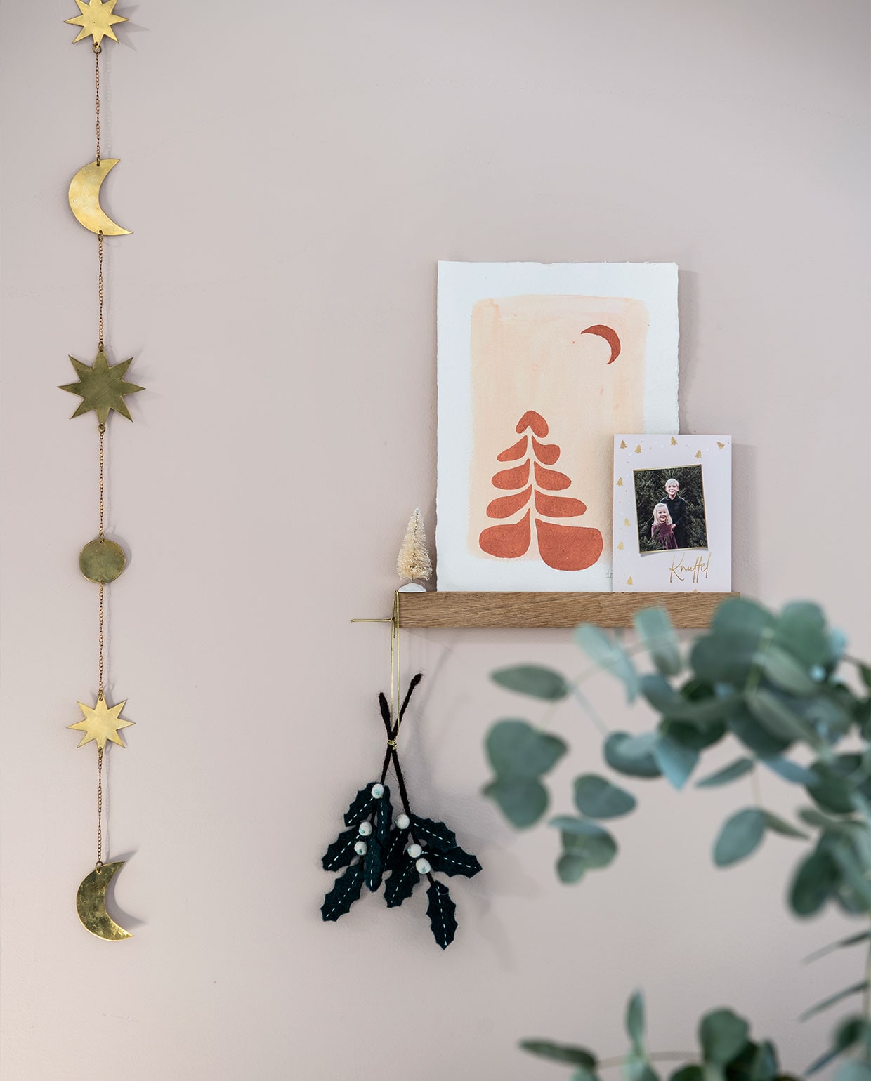 Guirlande Noor &amp; the Nomads. Houten wandplank Groovy Magnets. Kunstwerk Wewonderwall. Kerstdecoratie donkere bladen Dille &amp; Kamille. vtwonen 12-2021 | productie Insidehomepage | styling Laura Gommans | fotografie Louis Lemaire