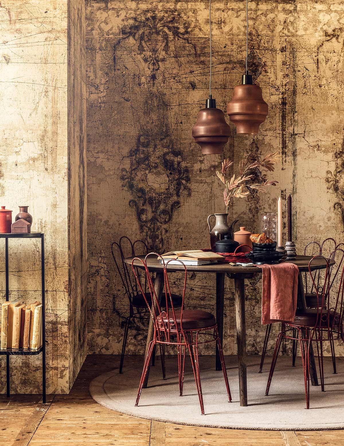 Behang Borgia (Wall&amp;decò). Hanglampen (De Weldaad). Eettafel (Homestede). Franse stoeltjes (tiltdesignenantiek.nl). Kleed (Sofacompany). Zwart tafeltje (Bolia). Paars bakje in vorm van huis (Mobilia). Oranje potje met oor, paars vaasje (MaisonNL). Glazen vaas (Homestede). Dienblad (Linda’s hoekje). Kunsttak (De Weldaad). Zwarte schaaltjes (Pieter &amp; Tosch). Kandelaars (Things I Like Things I Love). Potten (H&amp;M Home). Servet en kaars privébezit. vtwonen 09-2018 | Fotografie Sjoerd Eickmans | Styling Liza Wassenaar