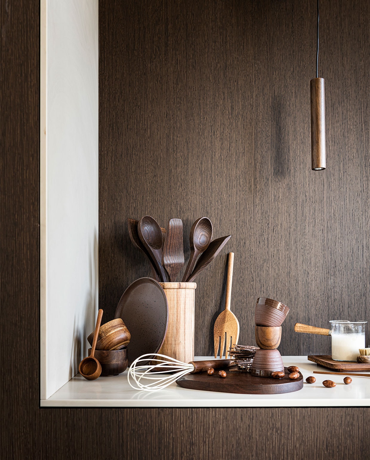 Panelen met behang met houtprint Essences de bois – RM 430 75 van Elitis, per meter € 135,- (loggerewilpower.com). Houten mokken van Serax € 13,60, houten keukengerei van Serax, set van 5 € 53,-, houten hanglamp van Umage € 75,-, rechthoekig houten bord van Serax € 25,- (vtwonen.nl). Rond bruin bord € 22,90, bruine espresso mokken, per stuk € 6,90 (letoile.store). Houten pot € 29,99, houten koffielepel € 9,99, houten garde € 11,98, houten vork uit slacouvert € 17,99, melkkan met houten handvat € 15,99 (zarahome.com). Houten eierdop, per stuk € 3,99 (sissy-boy.com). Overig privébezit. vtwonen 11-2021 | styling Danielle Verheul | fotografie Sjoerd Eickmans | m.m.v. Soekijad (vloer) | assistentie Sanne Ketelaar, Niels Kist, Kula van den Broek