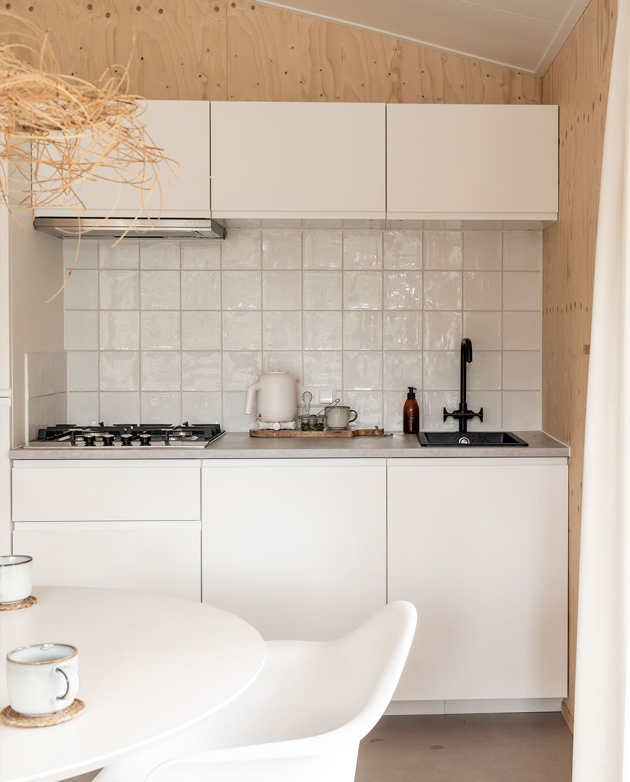 Keuken, kraan Ikea, tegels Schippers tegels. Houten plank, zeeppompje herkomst onbekend. Waterkoker Hema, kopjes Ikea, onderzetters Calma House, lamp Earthware, tafel Wehkamp, stoel Vintagelab15. vtwonen 11-2021 | Fotografie Muk van Lil | tekst Cathelijne van Wingerden