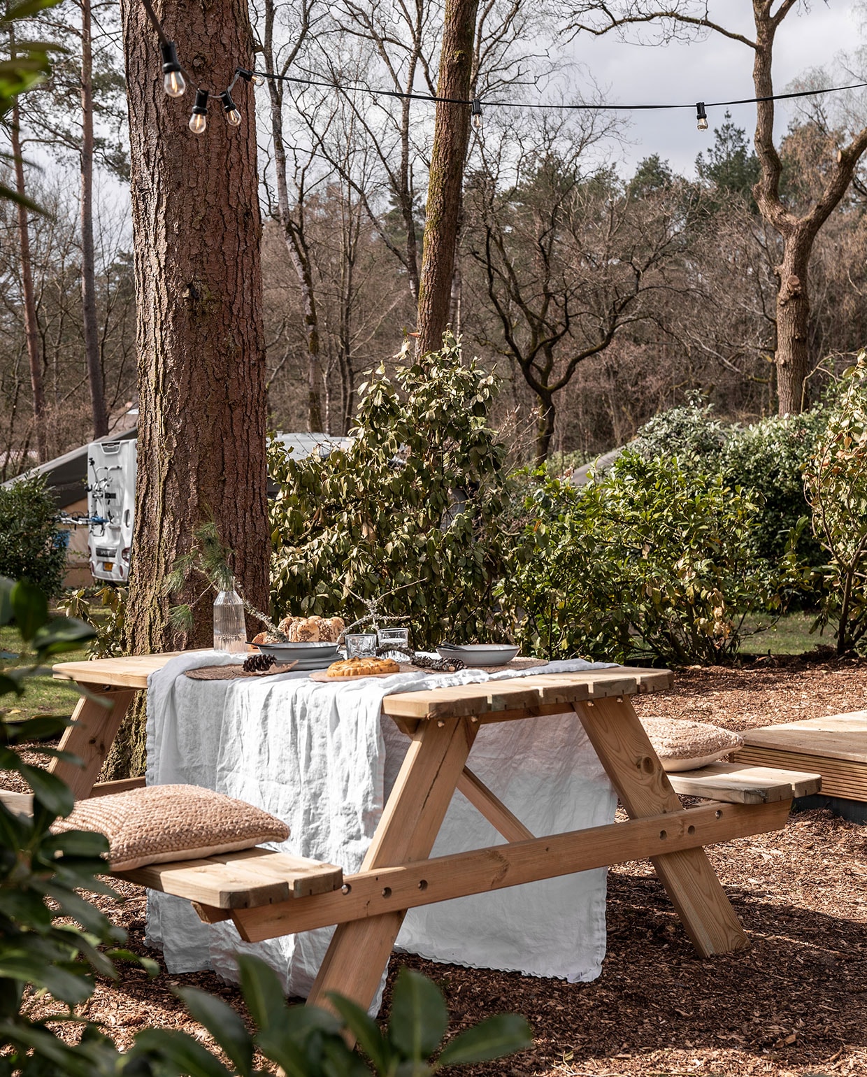Picknicktafel herkomst onbekend, kleed H&amp;M Home. Servies, karaf, glazen Ikea. Kussens Calma House, lampenslinger Marktplaats. vtwonen 11-2021 | Fotografie Muk van Lil