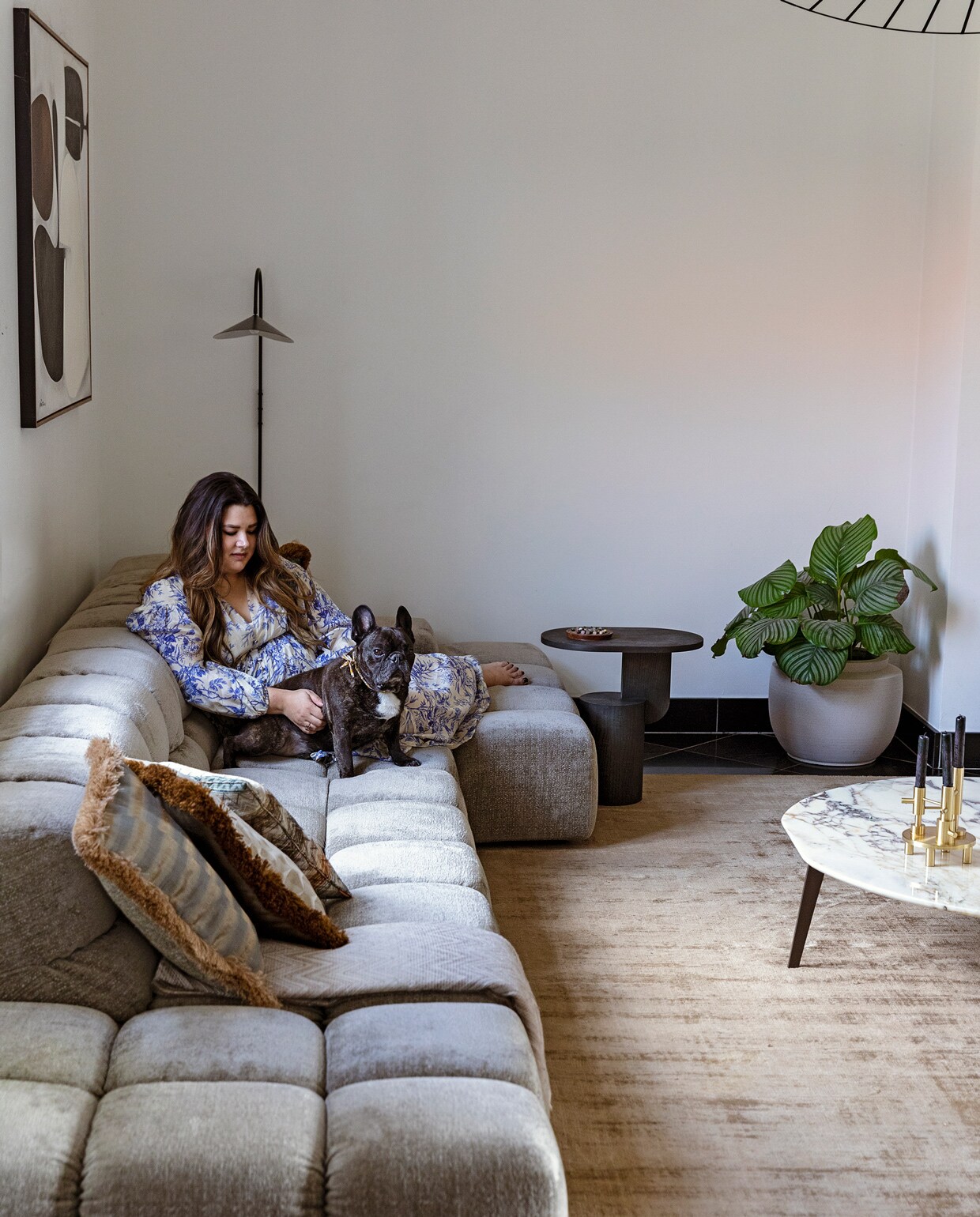 Vloerkleed Benuta. Marmeren bijzettafel Papadatos Decor Amsterdam. Kaarsenstandaard Fritz Hansen. Bank Tufty Time van BB Italia. Kussens Nox Studio Interiors en Missoni. Schilderij Ming Stylemeister. Wandlamp en zwarte bijzettafel Ferm Living. Plantenpot Serax. Plafondlamp Petite Friture via Interior Playground. vtwonen 11-2021 | Styling ilona jongepier | Fotografie dana van leeuwen | Tekst sara madou | Visagie djolien de kreij