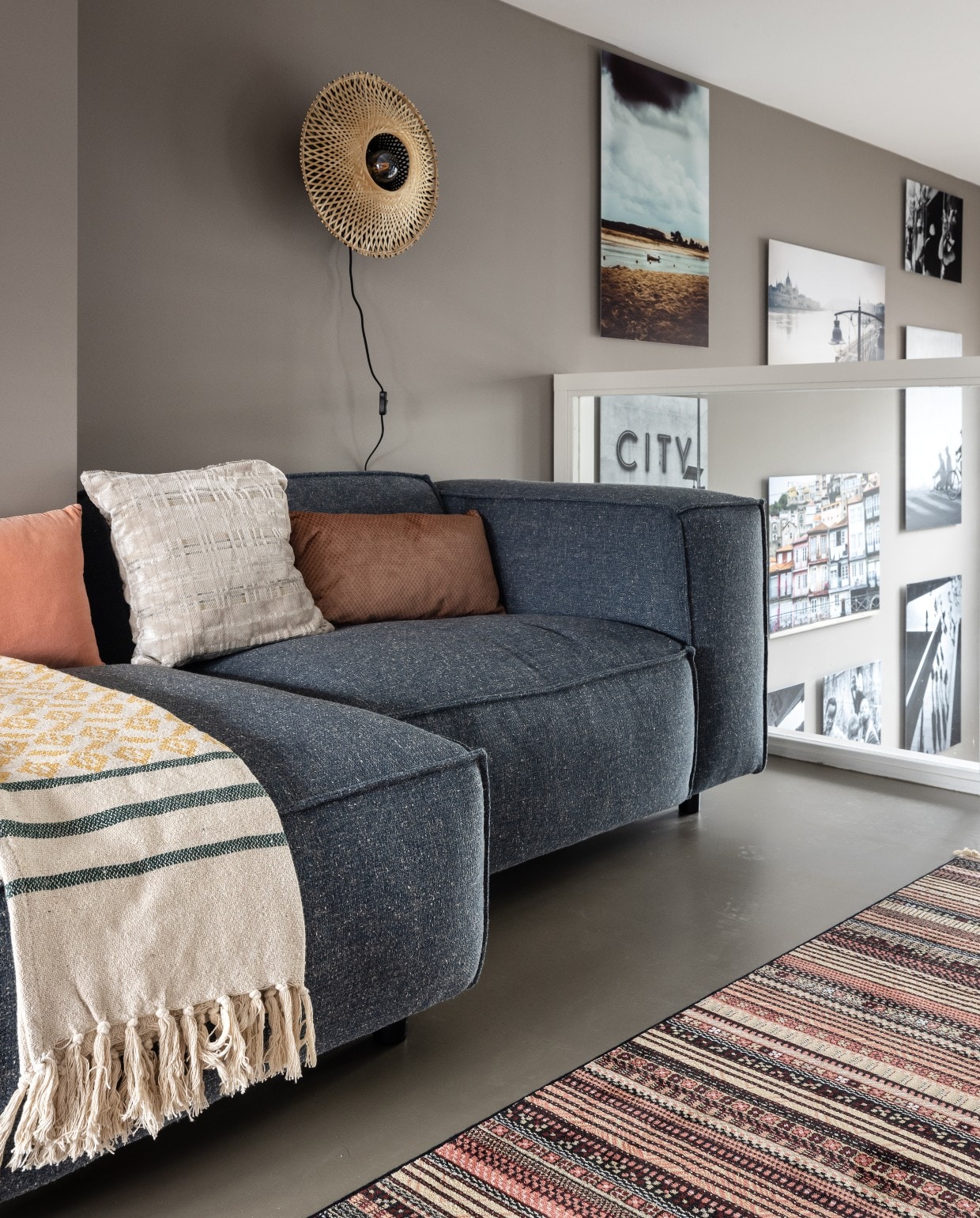 Wand achter bank in kleur Boomschornsbruin, Flexa. Elementenbank Amilly van Trendhopper, Eijerkamp. Bamboe wandlampen Kalimantan, Good&amp;Mojo. Nepal vloerkleed van Zuiver. Kussens met blauwe en grijze ruit Dandy, roze kussen Vintage van Urban Nature Culture, vtwonen. Kussen cirkel Club, Zuiver. Plaid van Bloomingville. Overig privébezit. vtwonen weer verliefd op je huis seizoen 15, aflevering 9 | styling Fietje Bruijn | fotografie Sonja Velda