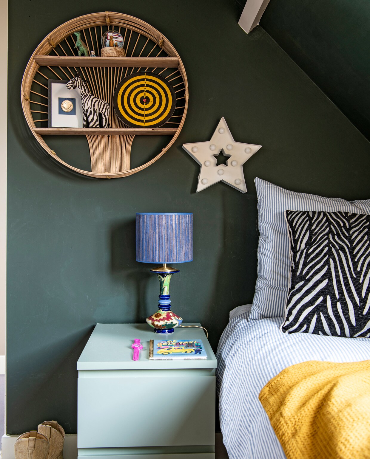 Muurverf Studio Green van Farrow &amp; Ball. Rotan wandkastje Madam Stoltz. Sterrenlamp Hema. Nachtkastje en dekbedovertrek Ikea. Lamp Madame Garage. Kussen en plaid Kwantum. vtwonen 10-2021 | Productie Insidehomepage | Fotografie Louis Lemaire | Styling en tekst Inge van Lieshout | Tekstbewerking Renate Dahlmans