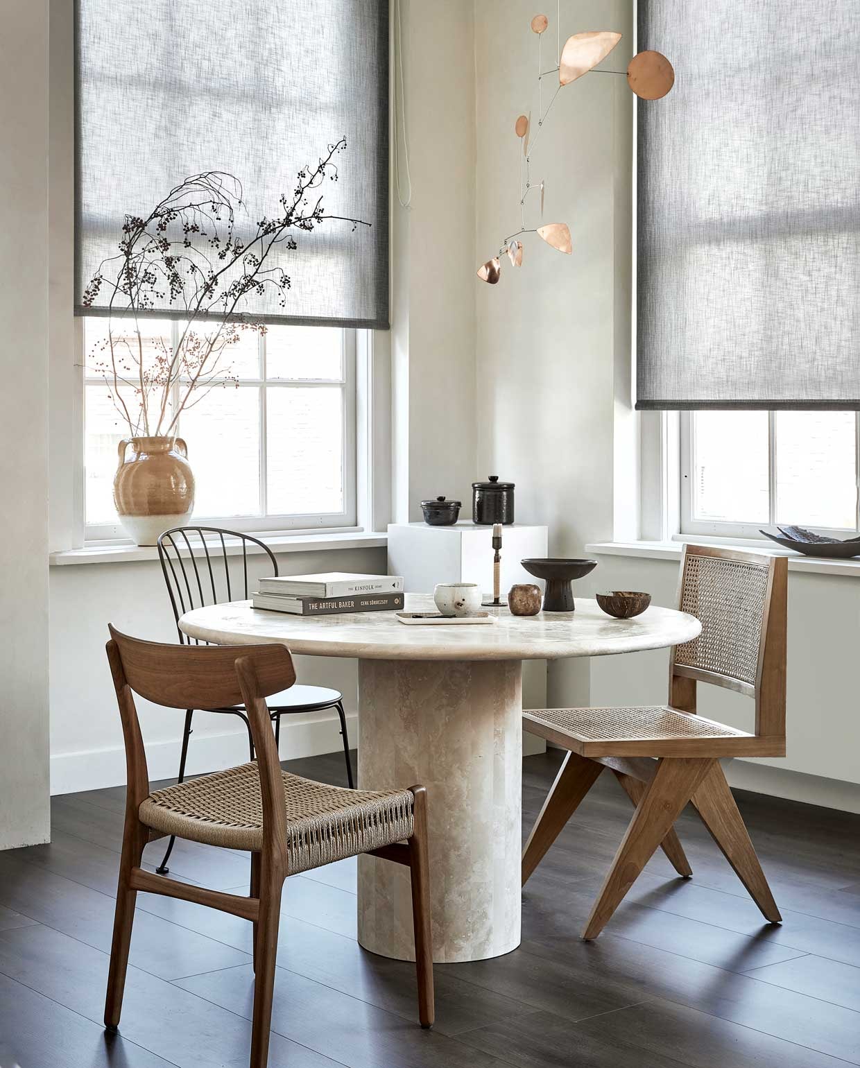Lichtdoorlatend , op maat gemaakt, in kleur Bruin structuur (18016) vanaf € 78,23 (vtwonen.nl)., M.m.v. karwei.nl (vtwonen EVC vloer kleur Rye), pantoufle-design.nl (tafel), misterdesign.nl (houten stoel CH23 van Carl Hansen, links), casagitane.com (schaal op voet), extravert.nl (stalen stoel Opéra van Fermob), aimetestudio.com (houten stoel Pierre, rechts), zarahome.com (vazen), zenza.nl (alabaster waxinelichthouder), thefinestore.com (kandelaar van Menu),lpln.de (mobile van Lappalainen), bauwerkcolour.com (muurverf in kleur Mykonos). Overig privébezit. vtwonen 09-2021 | styling Kim van Rossenberg | fotografie Peggy Janssen