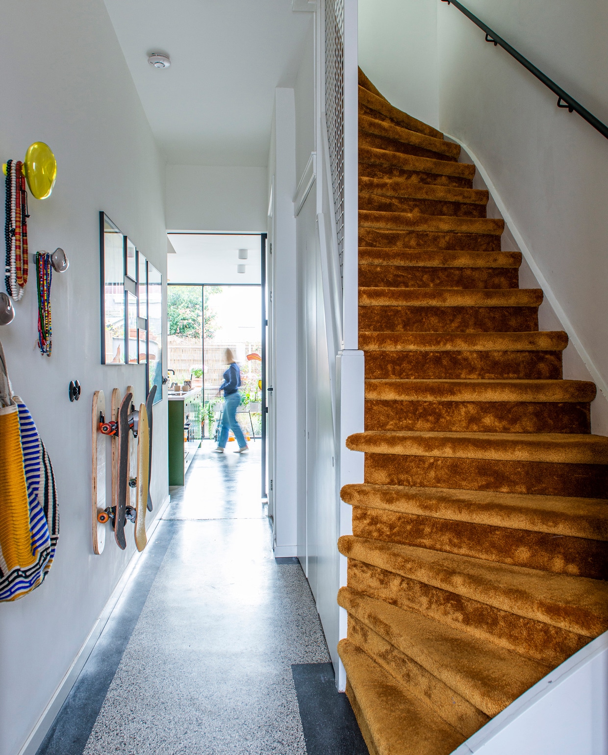 In de gang ligt de originele granitovloer uit de tijd dat het huis een drogisterij was. De trap is bekleed met velours voor een luxueuze uitstraling. Glazen hangers Petite Friture. vtwonen 09-2021 | styling Jeske Weel | fotografie Caroline Coehorst | tekst Chris Muyres