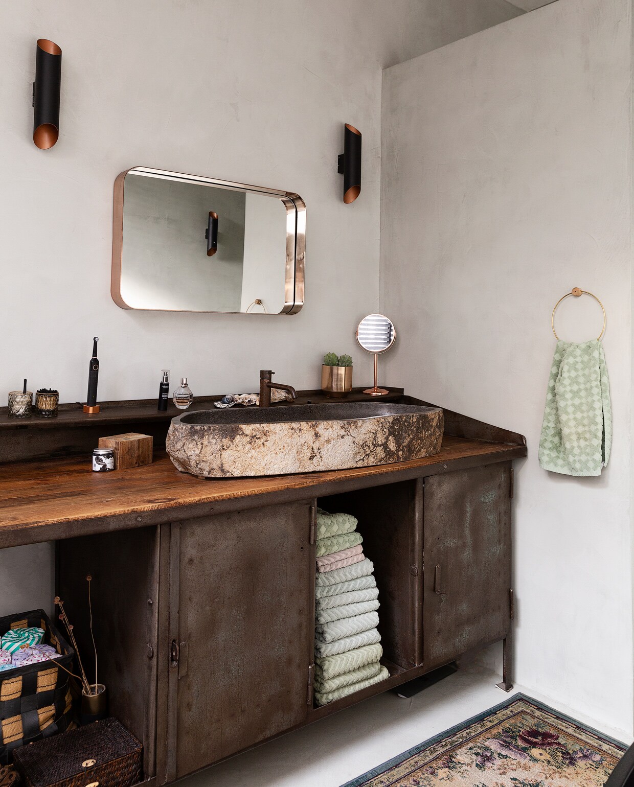 Oude werkbank Olde Looierij. Op maat gemaakte wastafel en kranen Hotbath, Meester Smeets. Spiegel Made. Wandlamp Agolada, Eglo. Vloerkleed Otto. Wanden en vloer Beton Ciré Pro (Zink), Trendstuc. vtwonen 10-2021 | styling Emmy van Dantzig | fotografie Jansje Klazinga