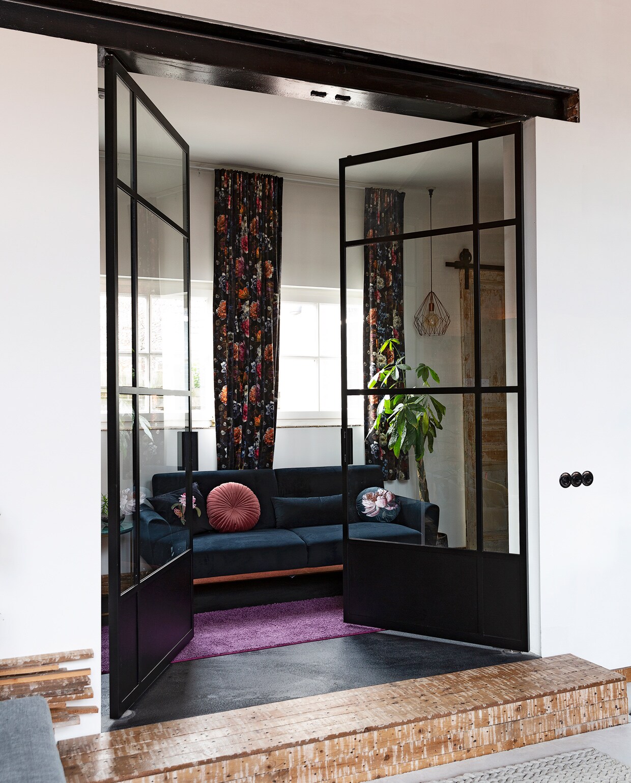 Bank Beliani. Hanglamp Praxis. Gordijnen Stoffenwinkel. De stalen taatsdeuren zijn een eigen ontwerp, uitgevoerd door TNW Interieur. Retro bakelieten wisselschakelaars Bakeliet. vtwonen 10-2021 | styling Emmy van Dantzig | fotografie Jansje Klazinga