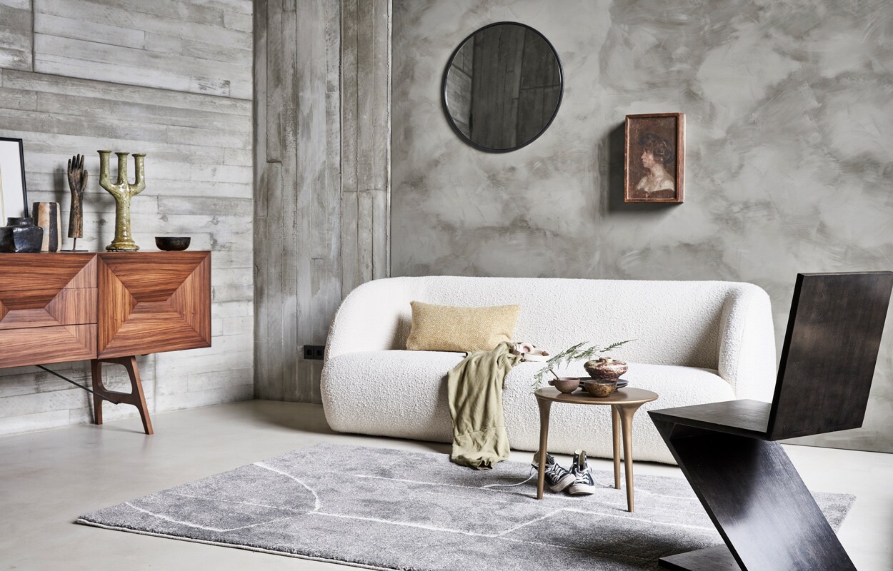 Vloerkleed Abstract in grijs,160×230 cm € 199,- (via Karwei). M.m.v. pure-original.nl (muurverf Fresco in de kleur Tundra), sofacompany.com (bank), couleurlocale.eu (salontafel, kussen, vazen, schaal, spiegel), vintage­hoarder.com (dressoir, hand op voet, stoel), converse.com (gympen), vtwonen.nl (plaid van Marc O’Polo). Overig privébezit. vtwonen 11-2021 | Productie Tanja Saarberg | Styling marlies Does | Fotografie  Bart Brussee\n