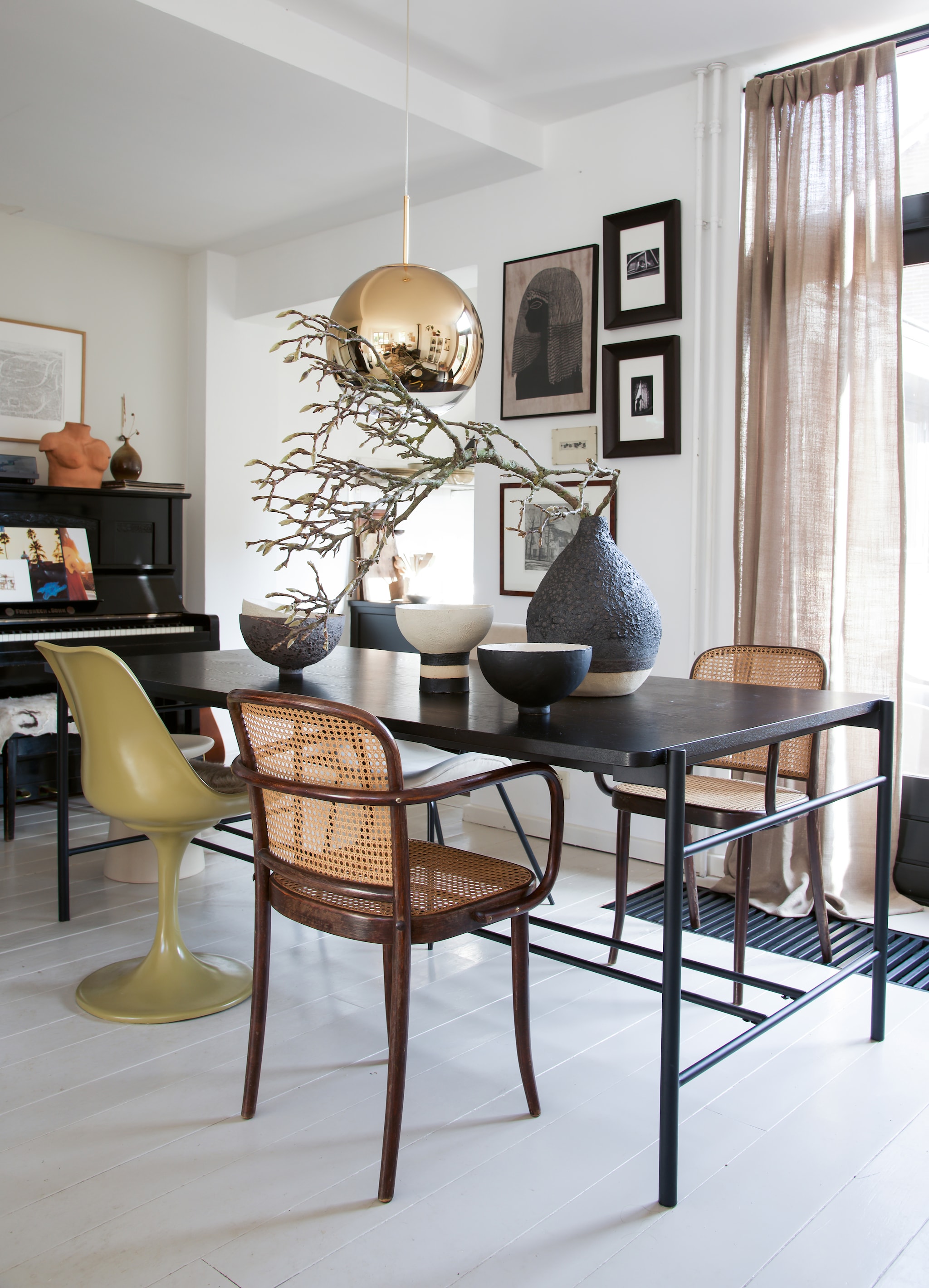 Oude Thonet-stoeltjes Marktplaats. Zwarte tafel Hübsch. Groene stoel met tulpvoet van Casa Gitane. Vazen en schalen handgemaakt door Liesbeth Spreeuwenberg. Designlamp Tom Dixon. Aan de wand een verzameling prints die Kris vond via Marktplaats en de kringloopwinkel. Foto’s via de kunstuitleen in Leiden. vtwonen 09-2021 | Styling José Spaans | Fotografie Barbara groen | Tekst Anne van den Dool