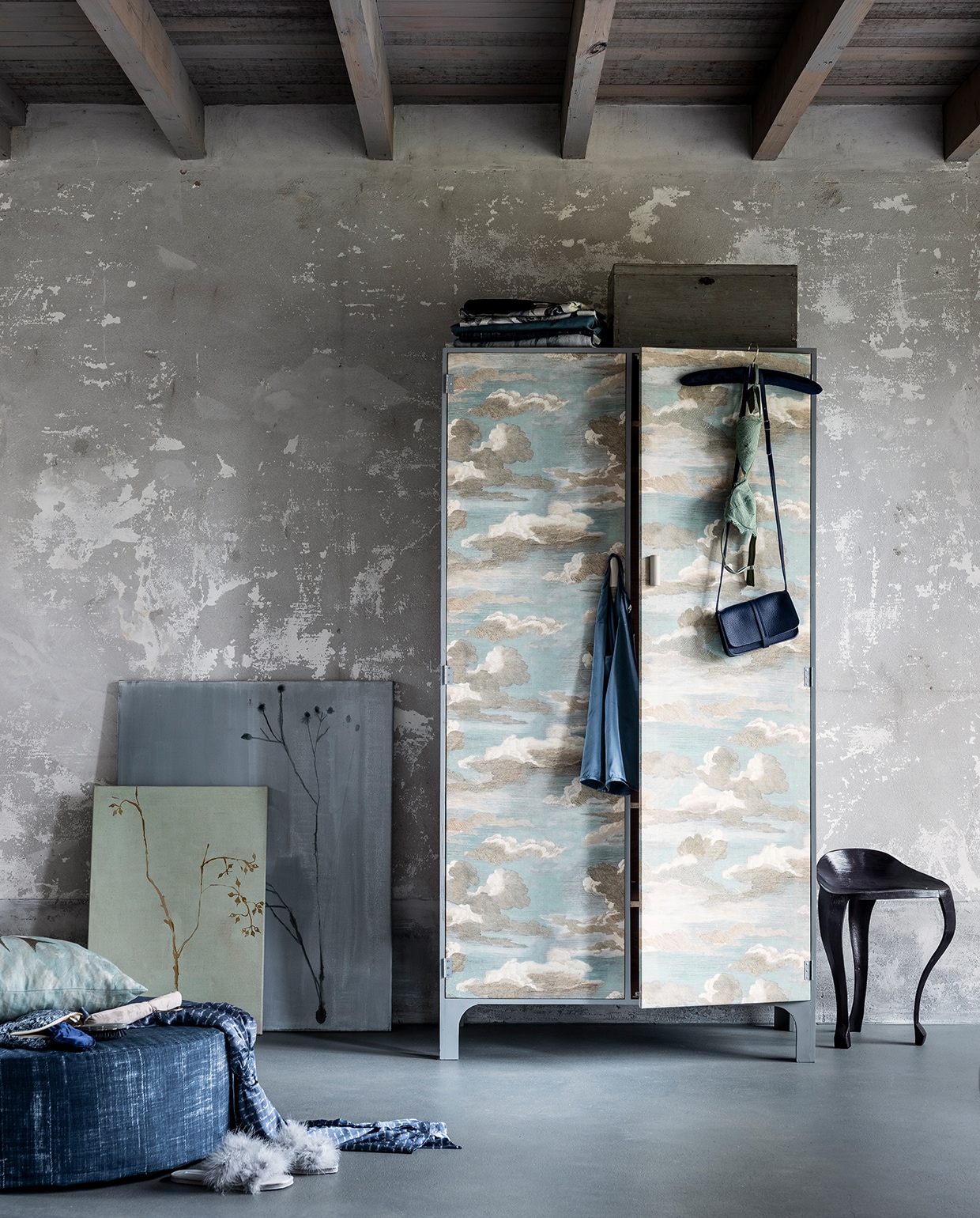 Kast, 170 x 90 cm (hxb), (com-anders.nl). Verf in kleur Manor House Gray (farrow-ball.com). Kussen van stof Chimney swallows sky blue van Designers Guild x John Derian (wva.nl). Schilderijen, (maartjevandennoort.nl). Poef bekleed met stof Niek (kwantum.nl). Blauw leren tasje (klevering.nl). Zwarte driepootkruk (maisonnl.com). Overige privébezit. vtwonen 03-2020 stof verf behang special | styling Danielle Verheul | fotografie Sjoerd Eickmans